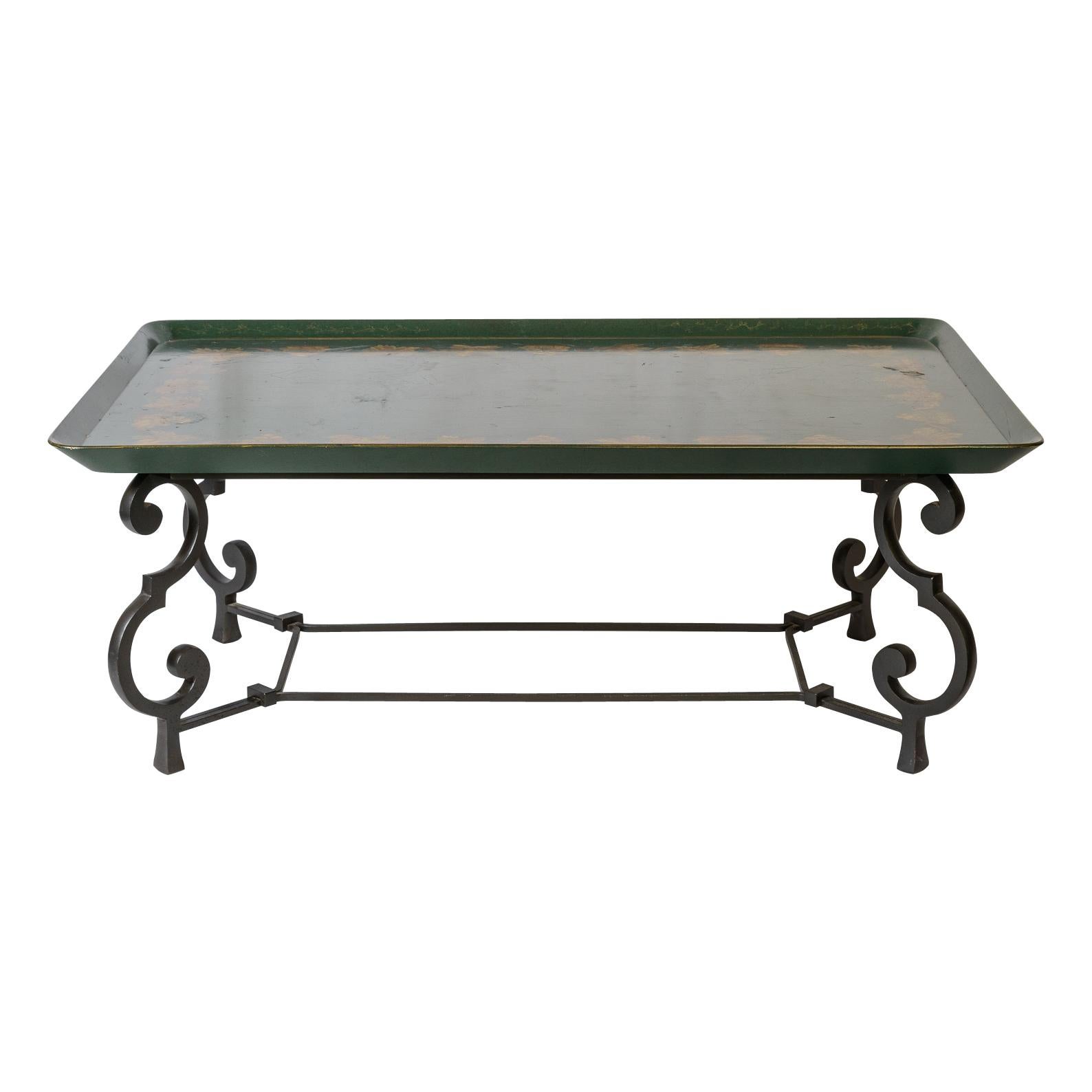 Nous venons de recevoir cette table basse en bois peint à la tôle et base en fer, attribuée à l'ébéniste français Maison Ramsay, datant du début du 20ème siècle.
Il s'agit d'un plateau en bois reposant sur une base en fer forgé à volutes.  il  est