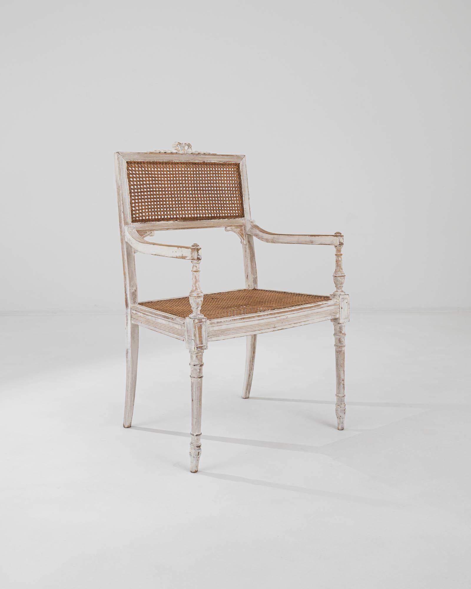 A wooden armchair created in early 20th century France. This timeless chair exudes a sense of distinguished and matured beauty. With finely curved and lathed legs and an octagonally woven wicker seat and back, this chair blends a classically