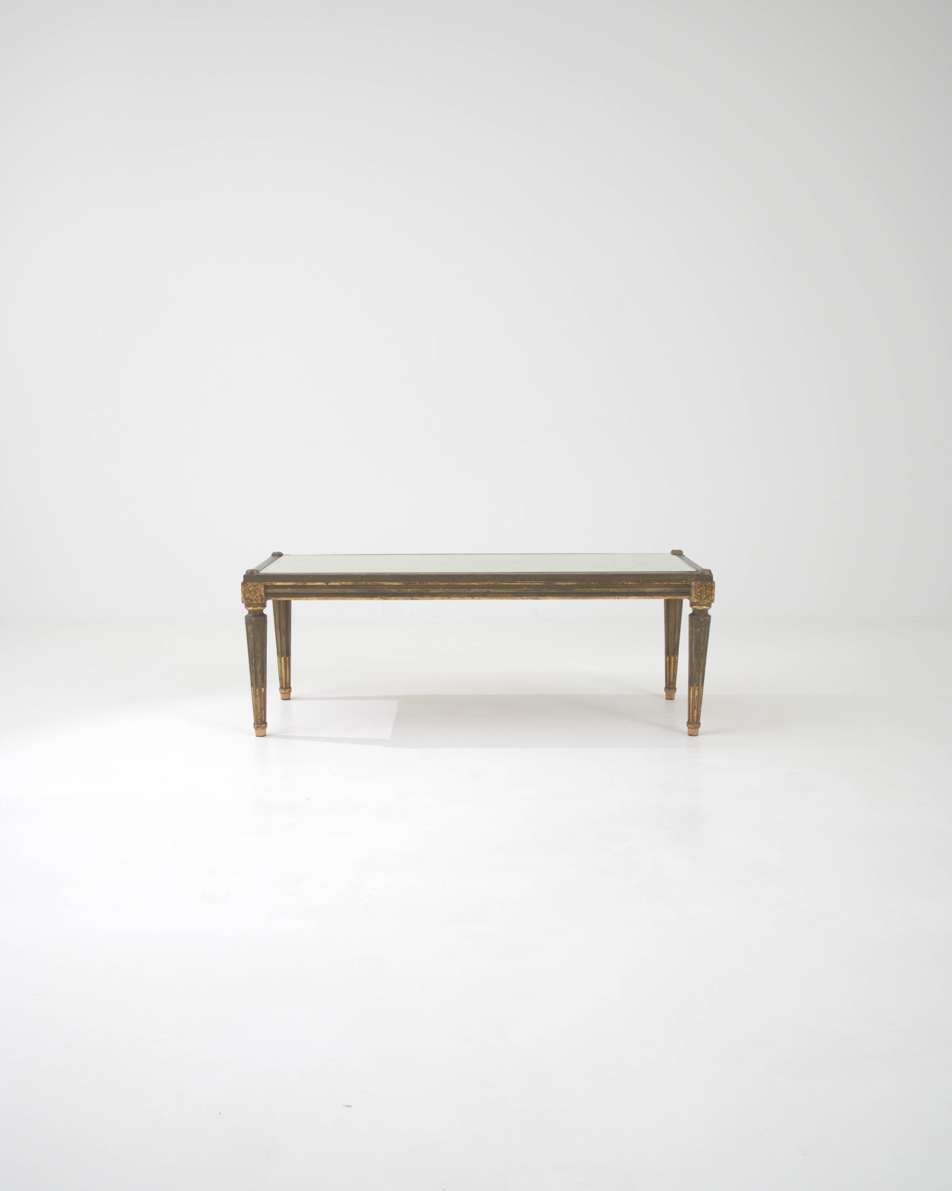 Presenting a masterpiece of early 20th-century French design, this exquisite wooden coffee table marries the rustic charm of its wood frame with the refined elegance of a glass top. The table's legs, adorned with delicate floral carvings, rise to