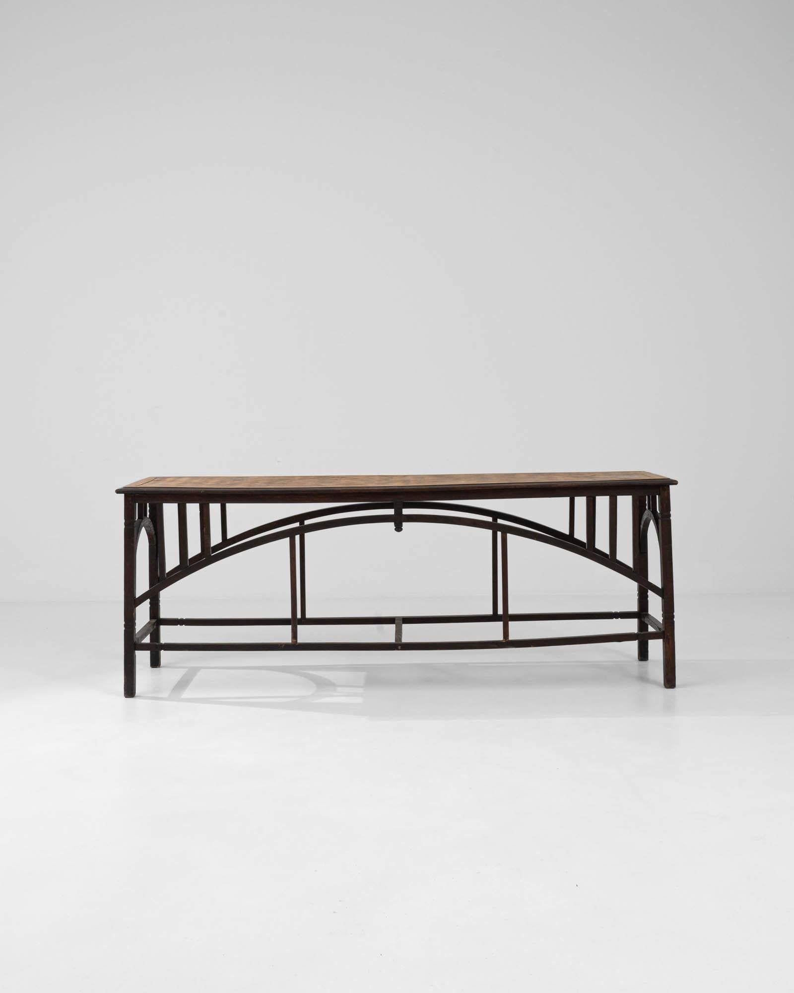 With a striking architectural silhouette and a beautifully crafted tabletop, this vintage wooden side table is a find to treasure. Made in France in the early 20th century, the multiple arches of the composition recall the Industrial elegance of the