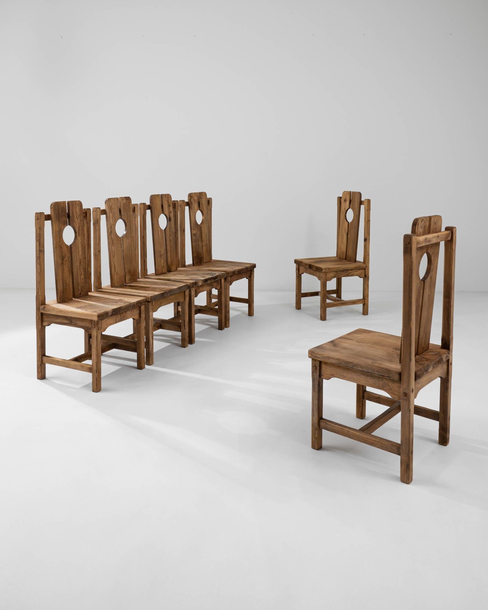 The unique design of this set of six dining chairs combines Provincial simplicity with the graphic tendencies of early Modernism. Hand-crafted in France in the early 20th century, peg joints and farmhouse-style struts celebrate traditional
