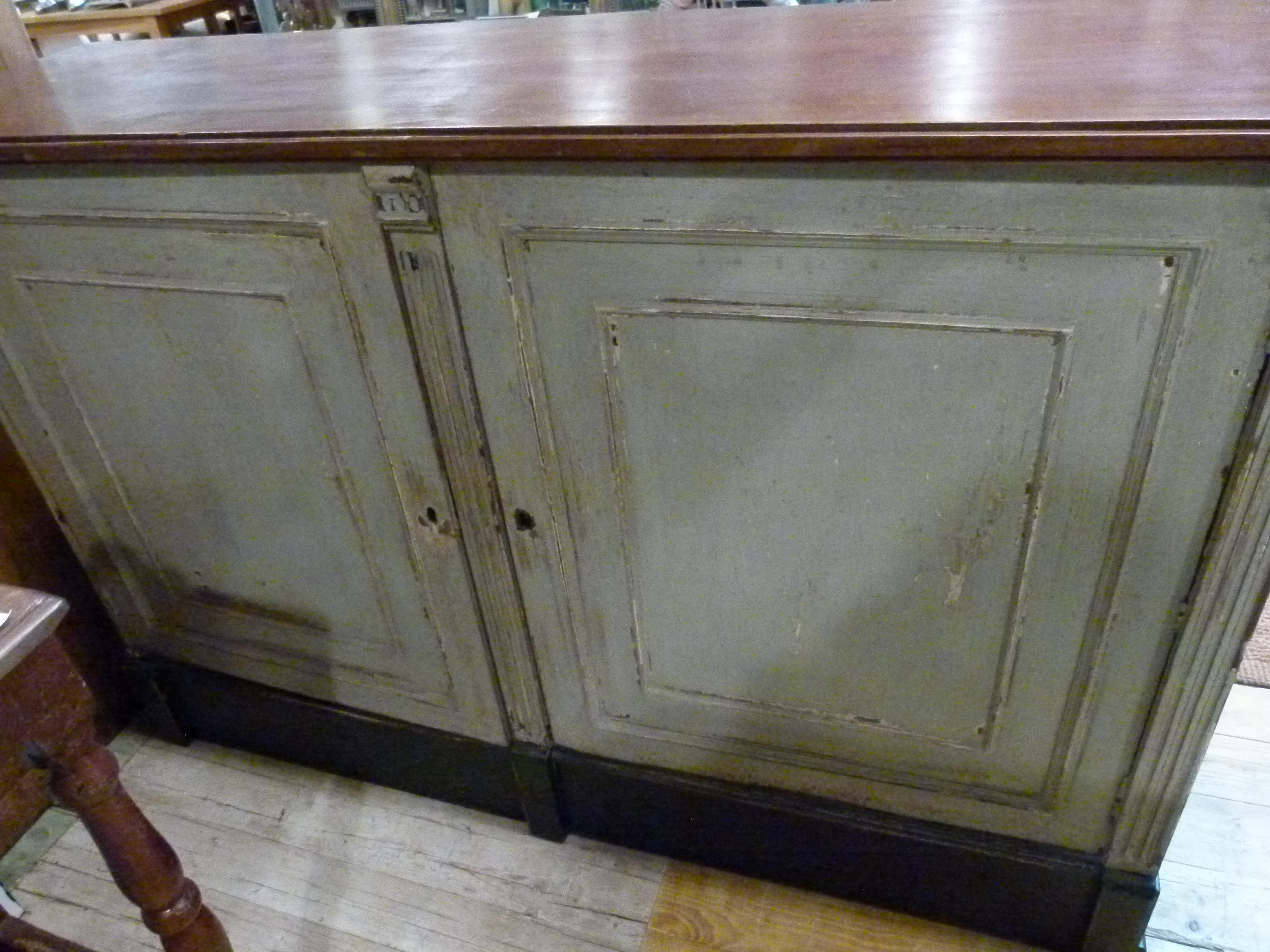 Early 20th century French wooden store counter. Painted in white except the countertop, that reminds in its original wood and the base painted in black. Two doors on the interior side open a cupboard with 2 shelves.
 