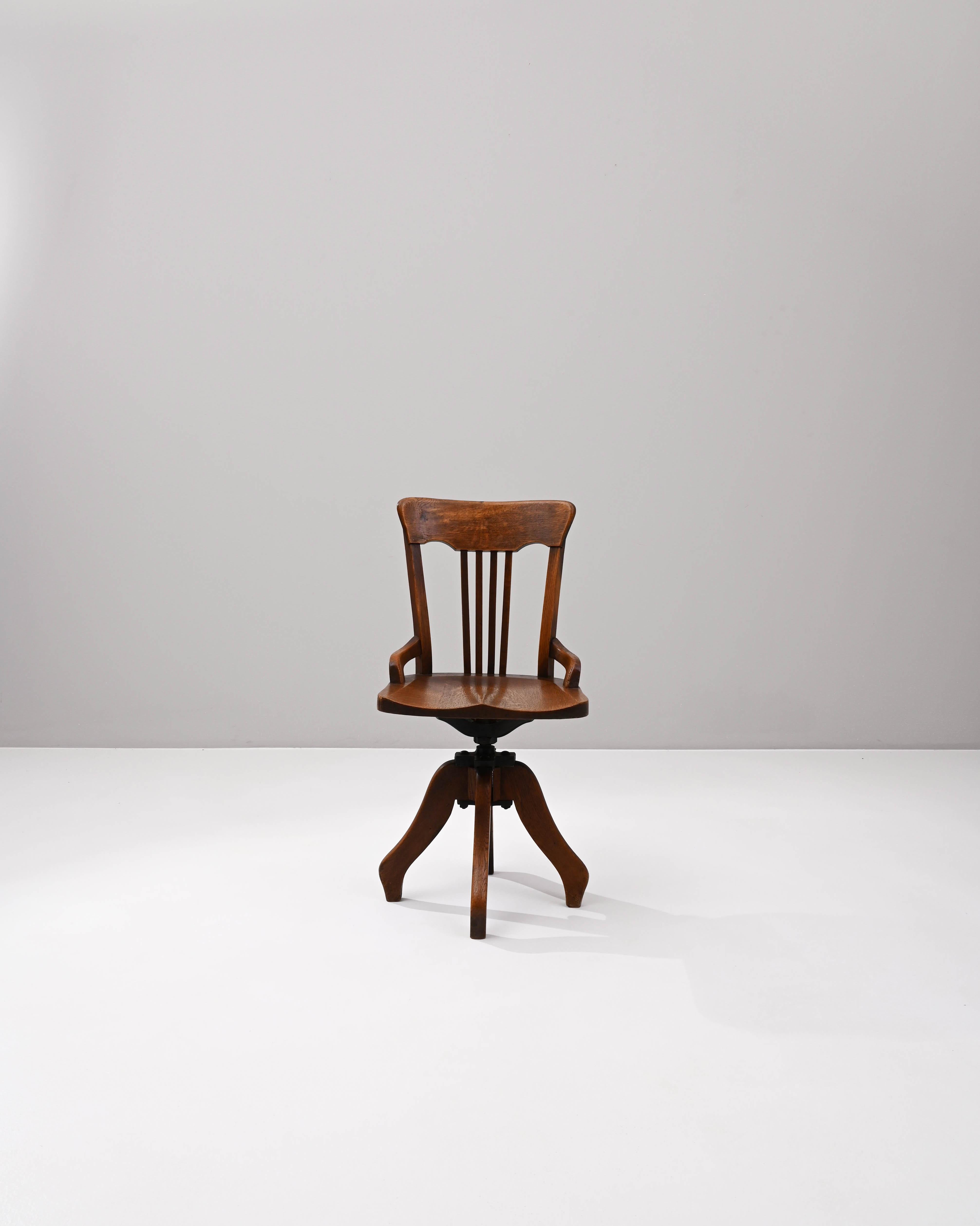 Erleben Sie den Charme des frühen 20. Jahrhunderts mit diesem französischen Holzdrehstuhl - eine reizvolle Verbindung von Funktionalität und klassischem Design. Der Stuhl lässt sich mühelos drehen und bietet so ein dynamisches Sitzerlebnis. Die