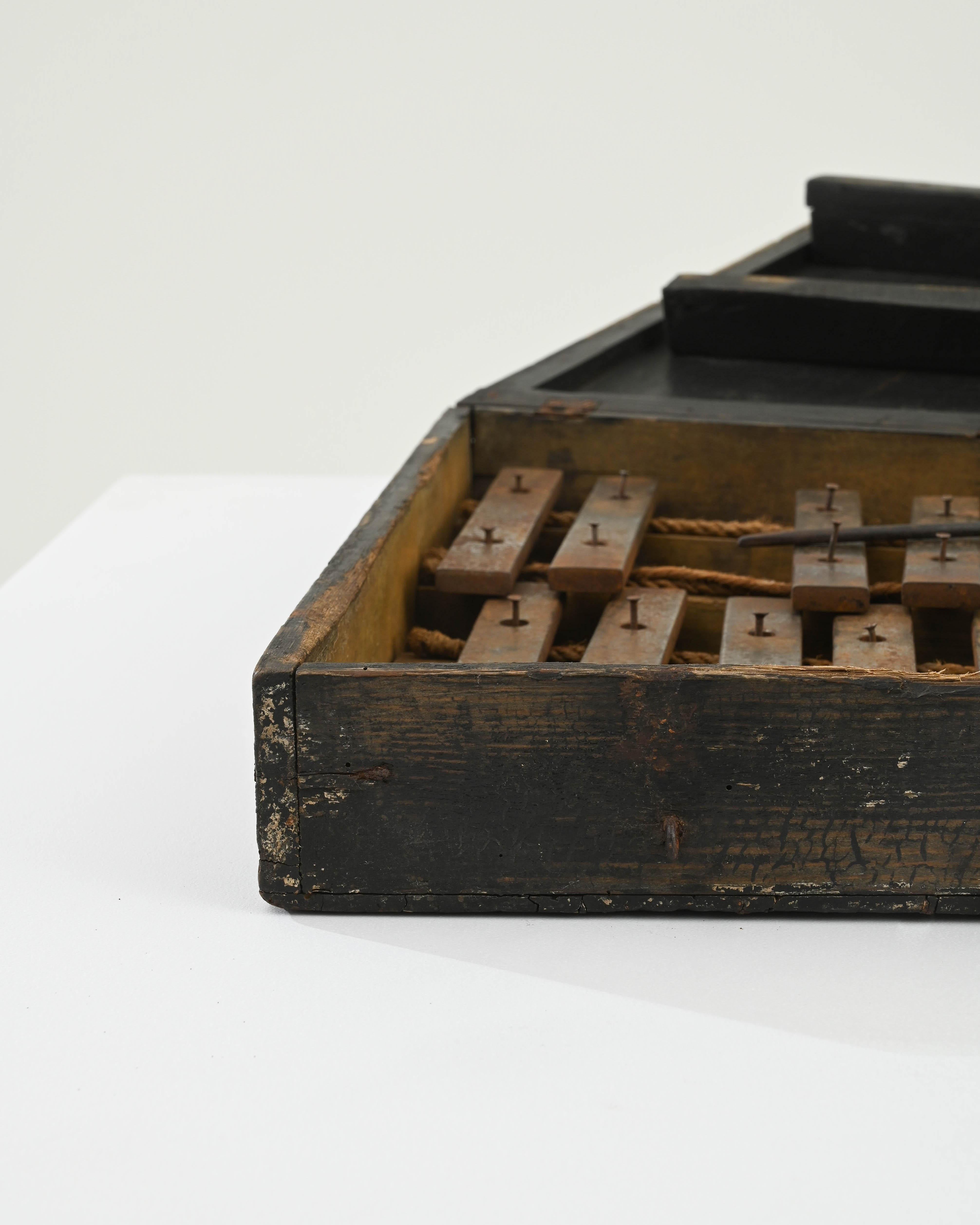 Entdecken Sie die bezaubernden Noten der Vergangenheit mit diesem französischen Holz-Xylophon aus dem frühen 20. Jahrhundert, einem musikalischen Schatz mit dem Charme vergangener Zeiten. Dieses Xylophon, das in einem edlen schwarzen Koffer steckt,