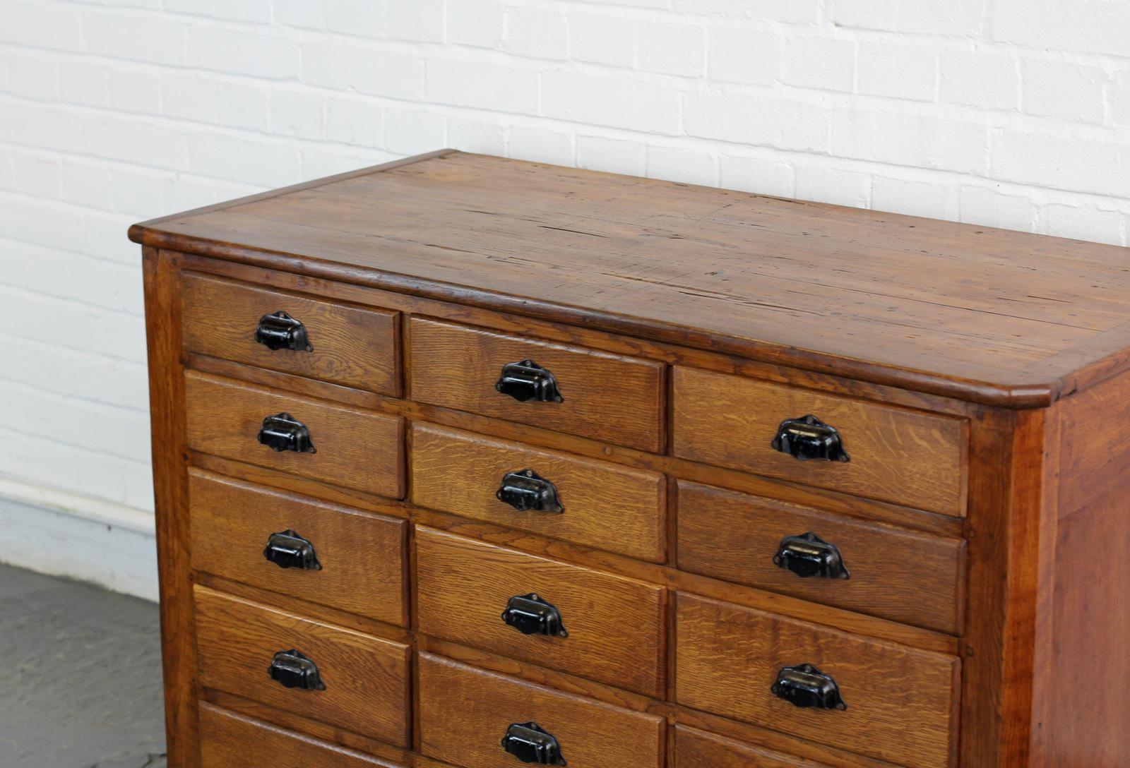 Early 20th century French workshop drawers, circa 1910.

- Solid oak frame and drawers
- Pine top
- Black steel handles
- French, circa 1910.
- Measures: 122cm wide x 60cm deep x 83cm tall.

Condition report:

The unit is solid and all the