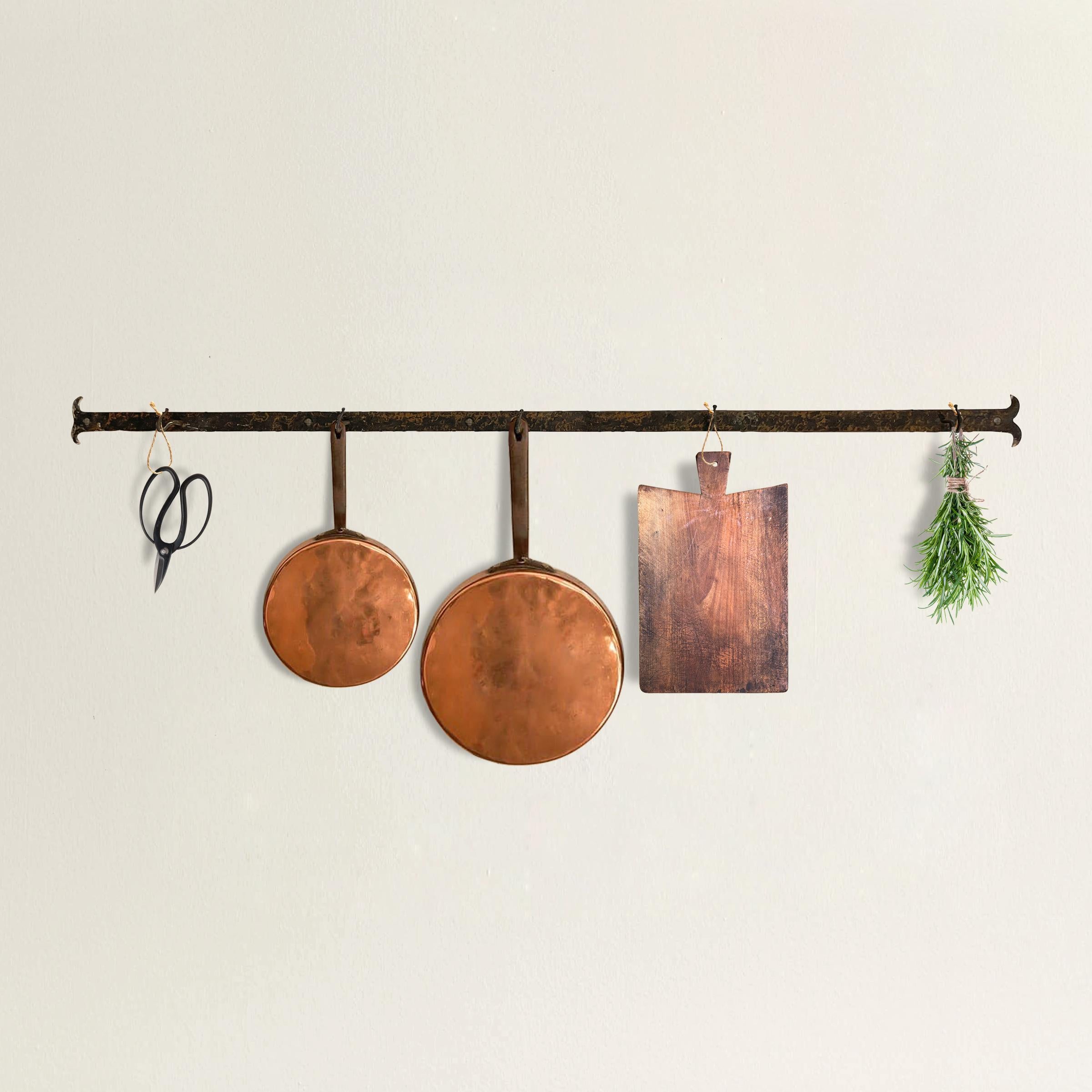 A simple yet refined early 20th century French wrought-iron wall-mounted pot rack with five hooks. Perfect for pouting above your stove to keep pots, lids, cutting boards, or any myriad things at your finger tips in the kitchen.