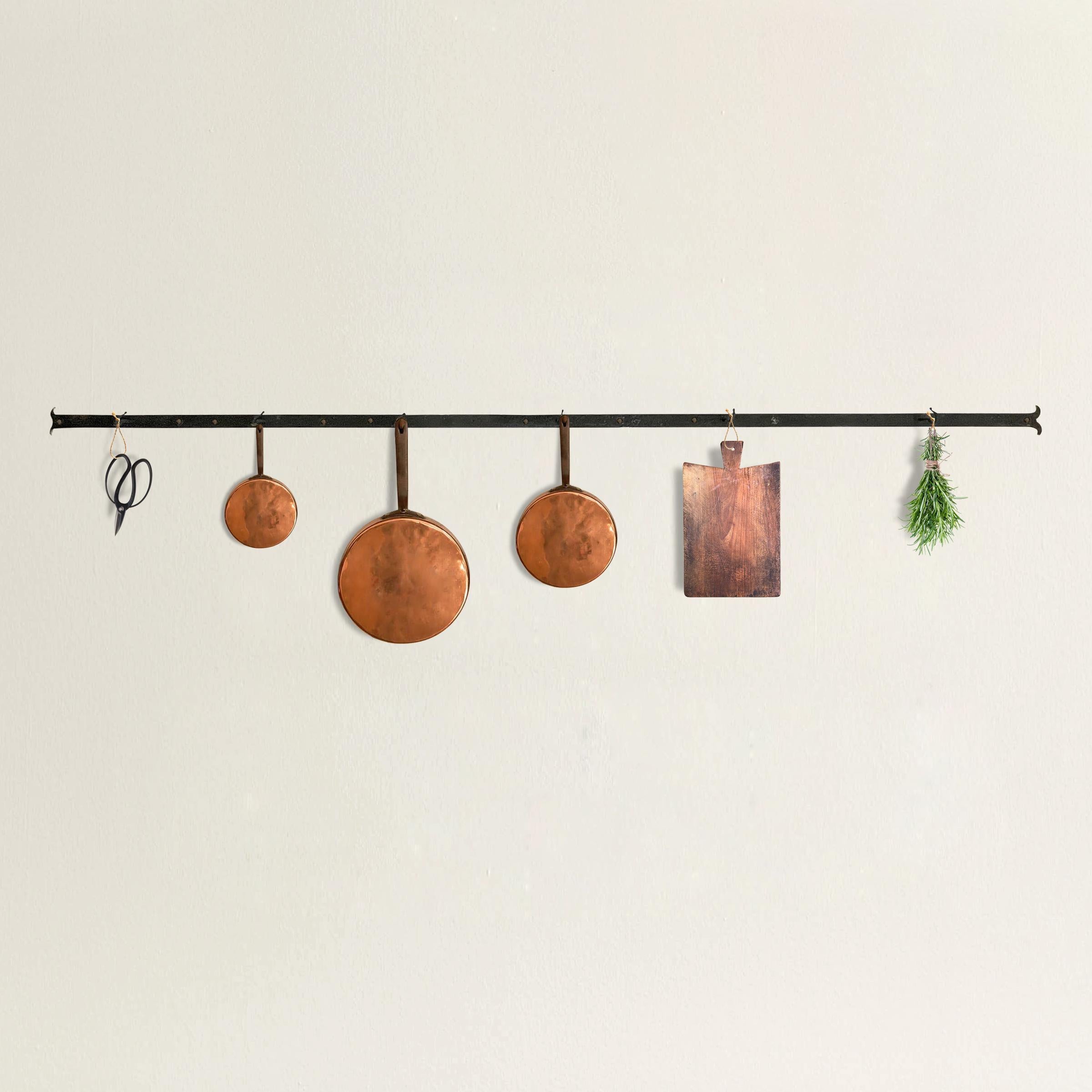 A simple yet refined early 20th century French wrought-iron wall-mounted pot rack with six hooks. Perfect for hanging on the wall above your stove to keep pots, lids, cutting boards, or any myriad things at your finger tips in the kitchen.