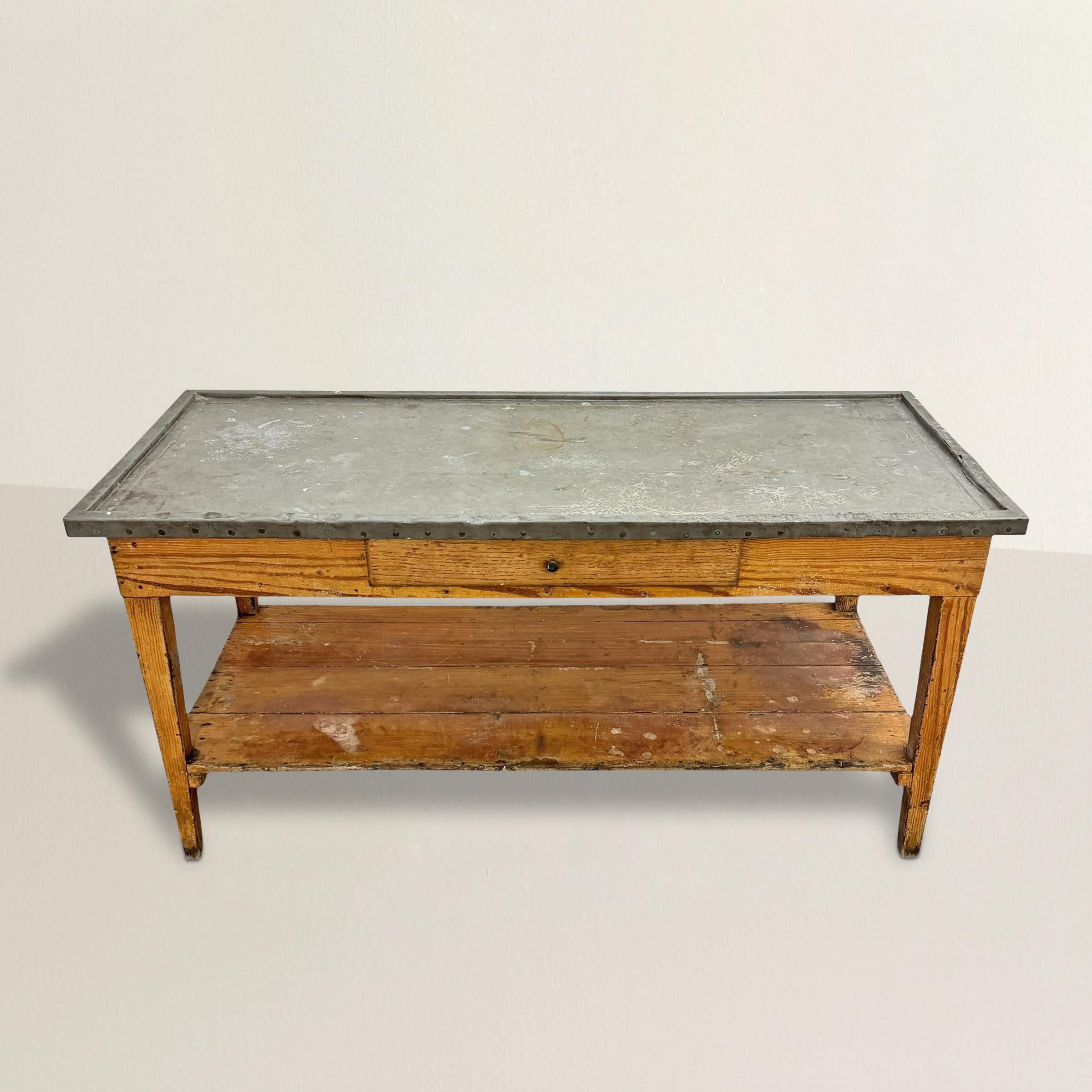 This early 20th-century French potting table, with its weathered zinc top and faux wood-grain painted finish, is the perfect blend of form and function. Originally designed for garden use, its zinc surface bears a patina of years spent supporting