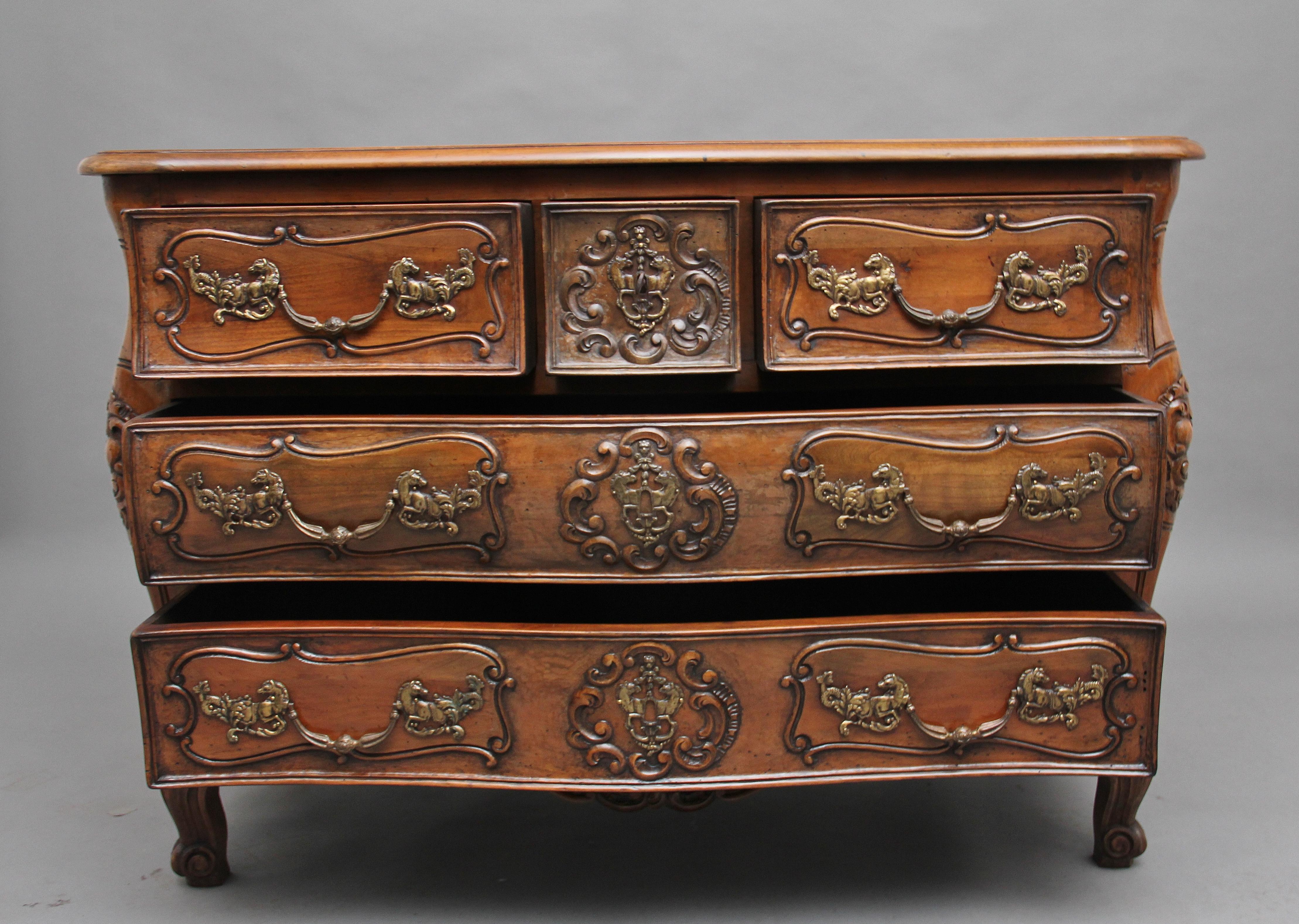A superb quality early 20th century French fruitwood commode of serpentine bombe form, having a shaped, moulded edge top above three small drawers over two long deep drawers with original brass handles and escutcheons, lovely carved drawer fronts,
