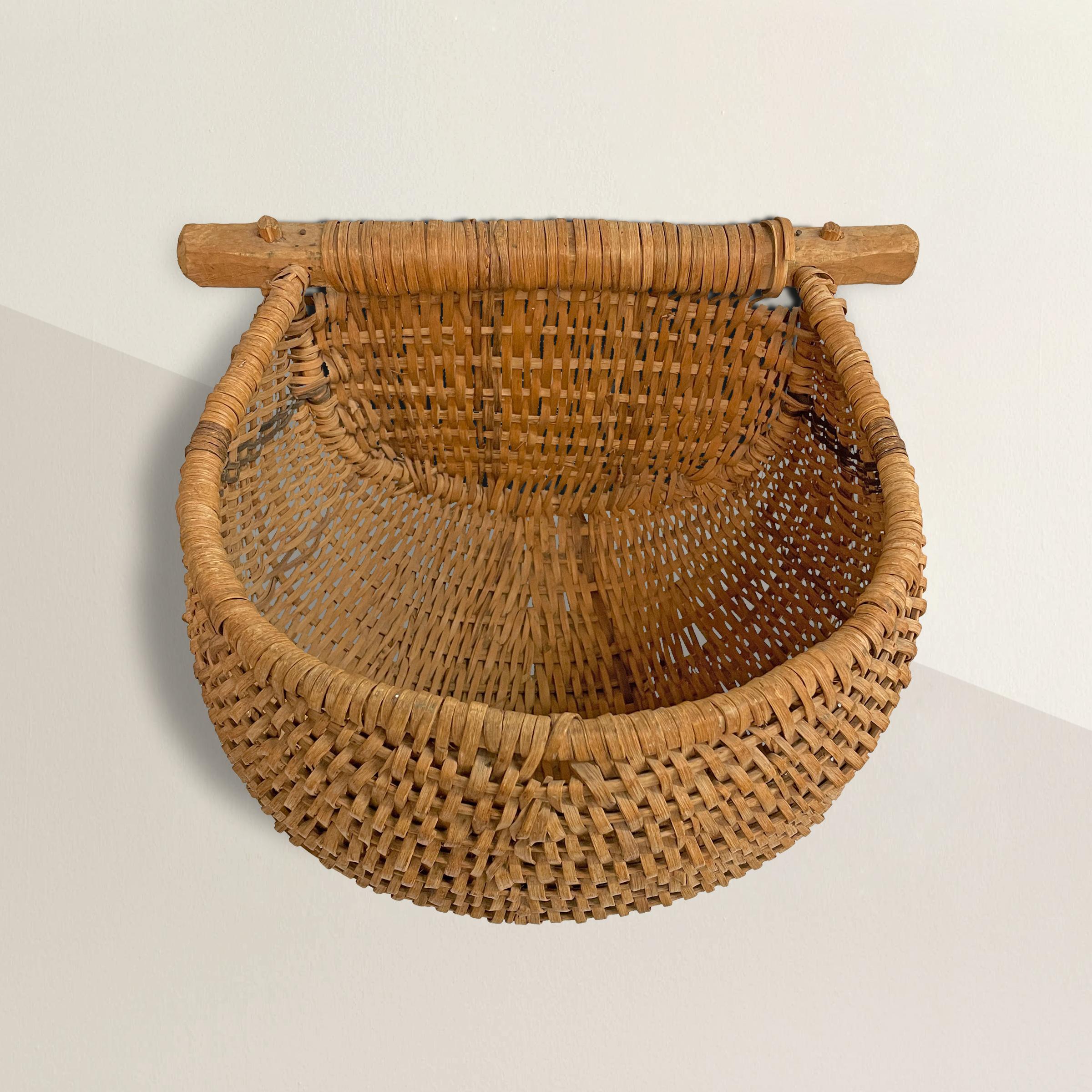 Early 20th century oak splint gathering basket with a large wood handle and plenty of room for holding berries, vegetables, or any myriad of floral. Today it's perfect for hanging on a wall and filling with seasonal flowers from your garden.