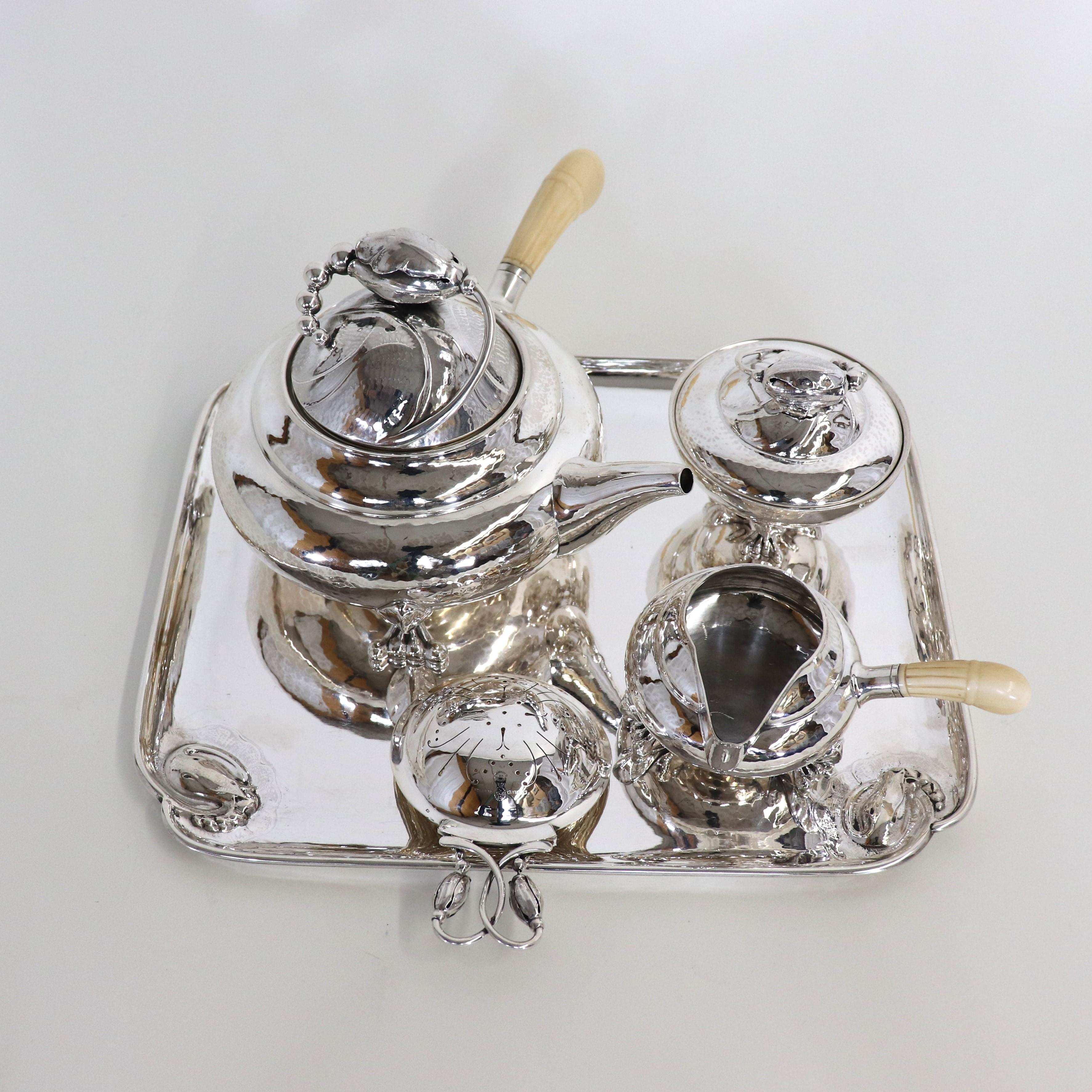 This exquisite and rare Georg Jensen (1866-1935) tea set is exemplary of the Art Nouveau style gloriously celebrating natural elements, specifically the magnolia blossom. The flower bud was inspired by Japanese art, which uses the magnolia bud and