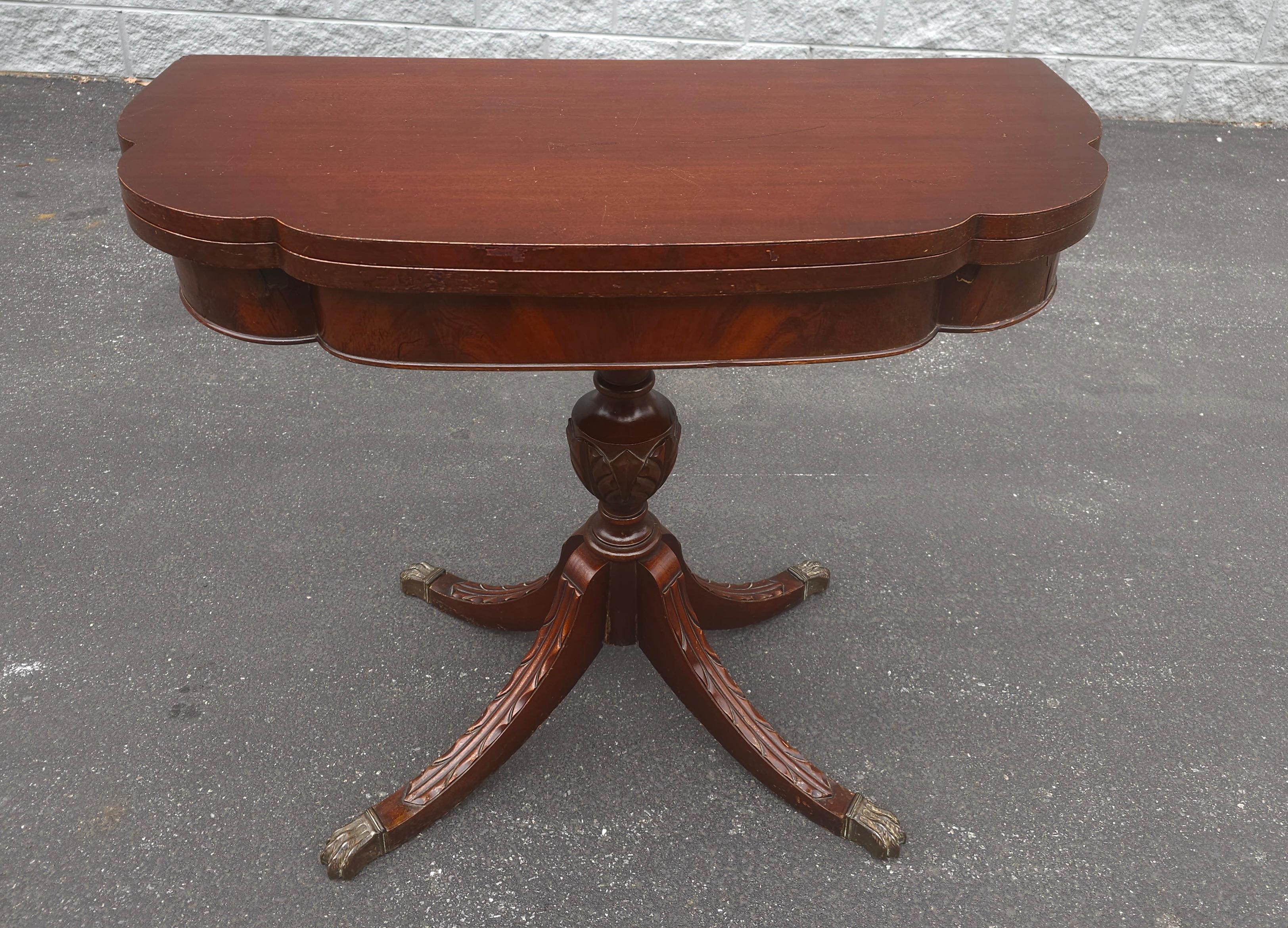 An Early 20th Century George III Style Mahogany Fold-Top Game Table Console Table with carved quad pod Pedestal and brass cap Paw Feet. Measures 36