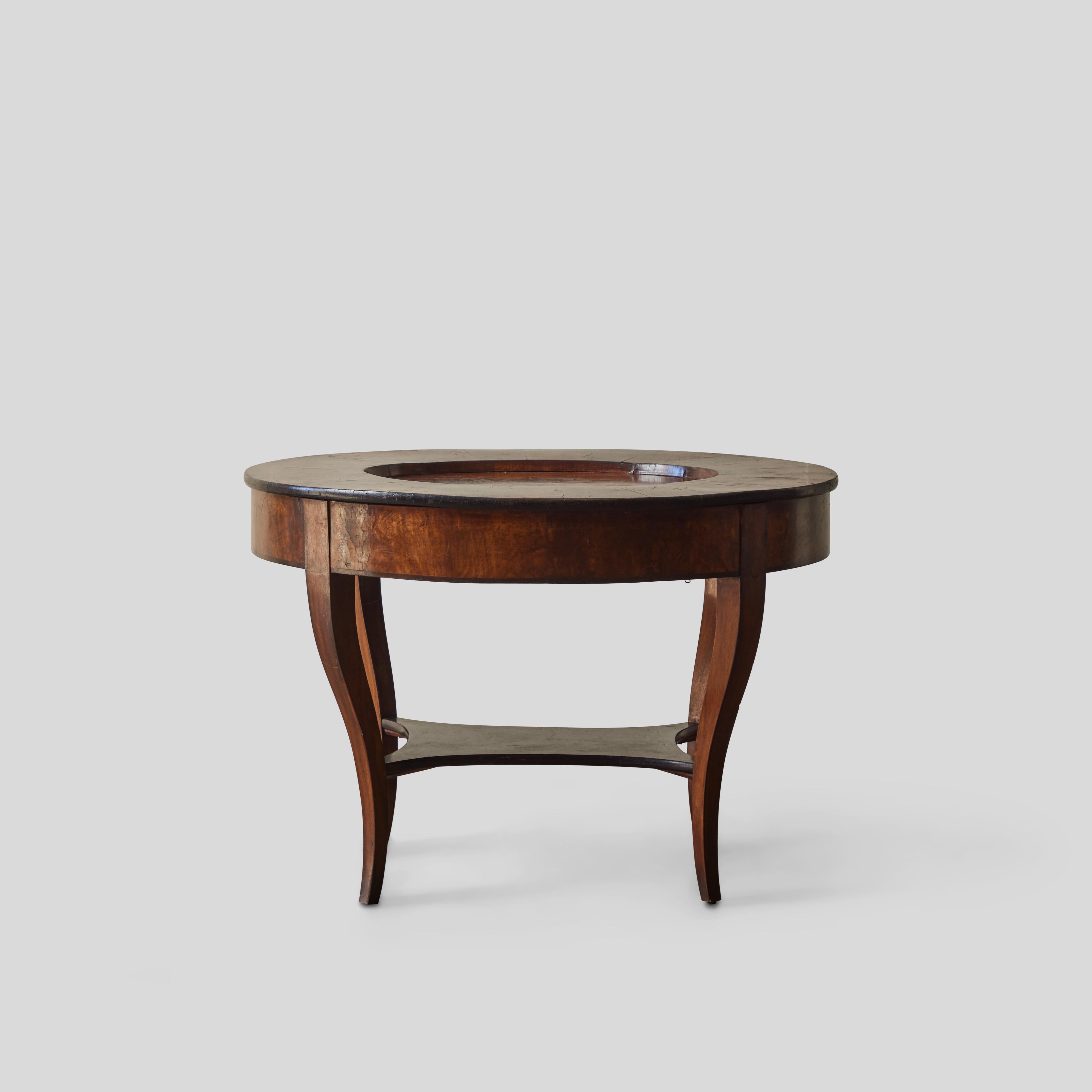 Georgian period circular side or coffee table made of rich, mahogany-toned burled wood. Georgian period furniture is known for its ability to function in a great variety of settings. With a sunken tray top, small lower shelf, and four elegantly