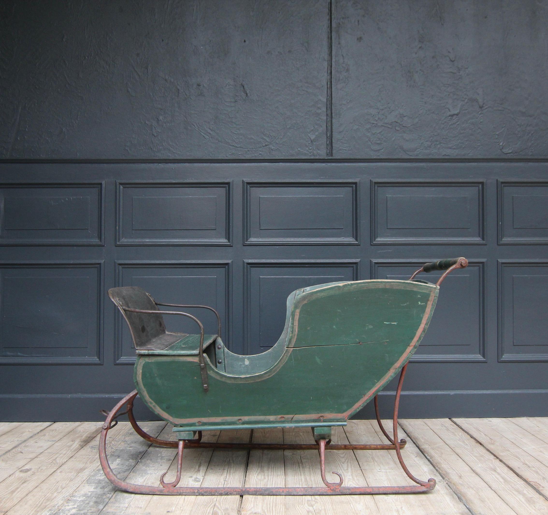 Decorative children's sledge or ice sledge from around 1900.

Made of painted wood and wrought iron.

For 3-4 children. Could be steered with the rear bar and pulled by a pony, billy goat or dog at the front.

Dimensions: 
68.5 cm or 77 cm high /