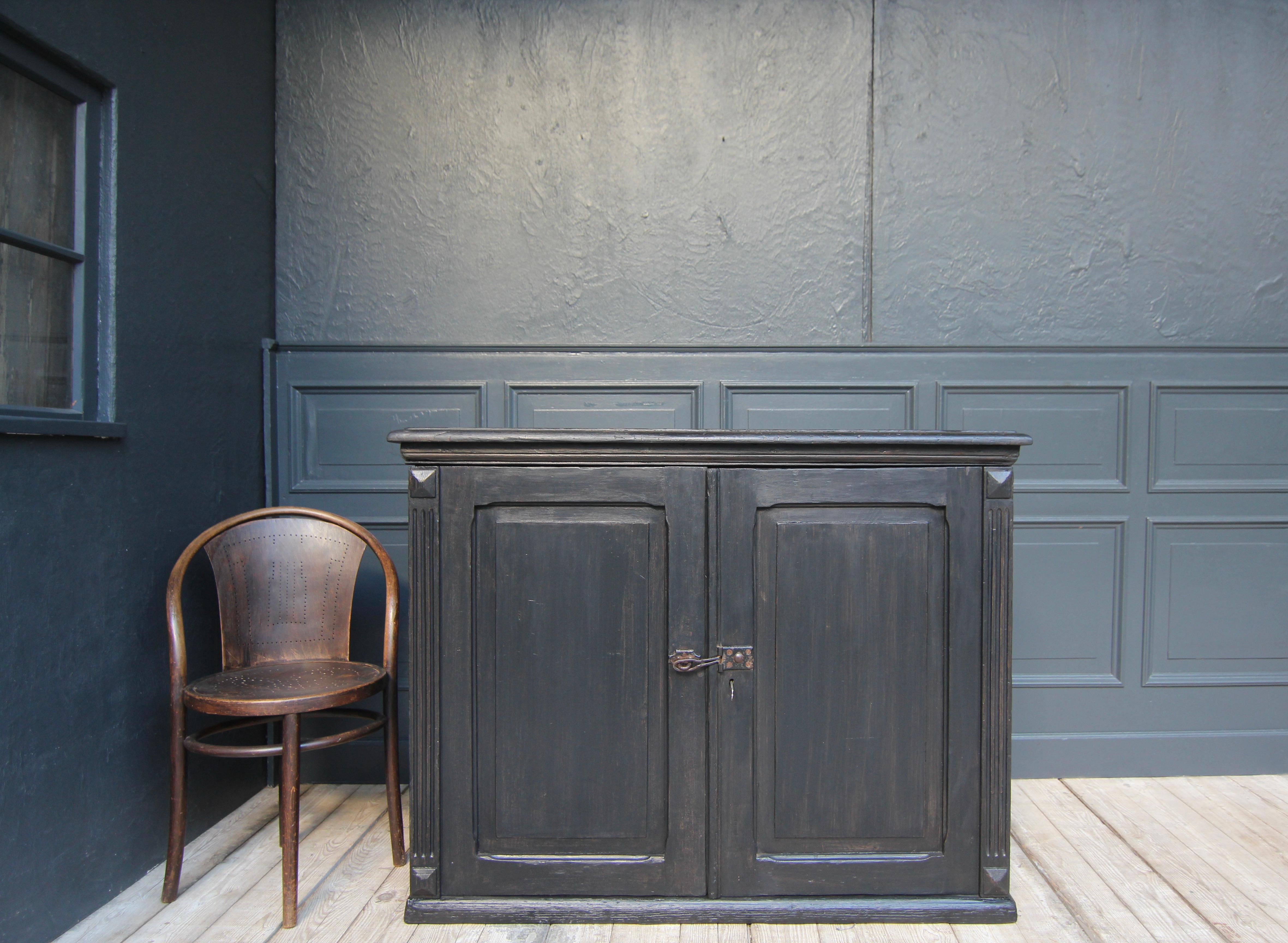 Early 20th century german plan cabinet from a factory office. 

All-round coffered cuboid ebonised solid wood body with 2 doors under a slightly protruding profiled top. Inside there are 10 shallow drawers in which large mechanical plans for