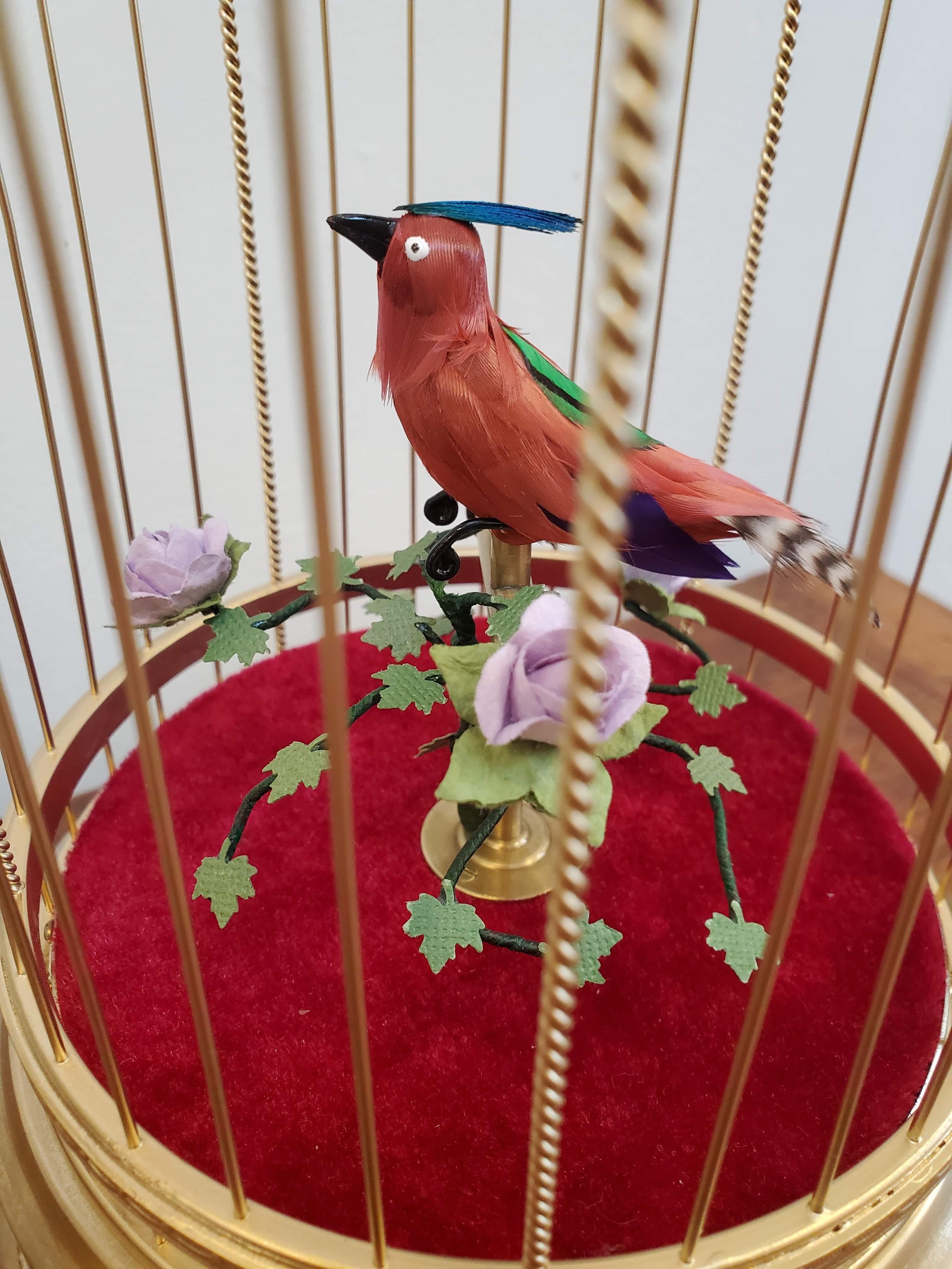This early 20th century musical bird automaton is an entertaining wonder of mechanics. Automated singing bird with a strong voice and flamboyant plumage amidst foliage in a gilded brass cage. The whole family will be fascinated by this lovely piece.