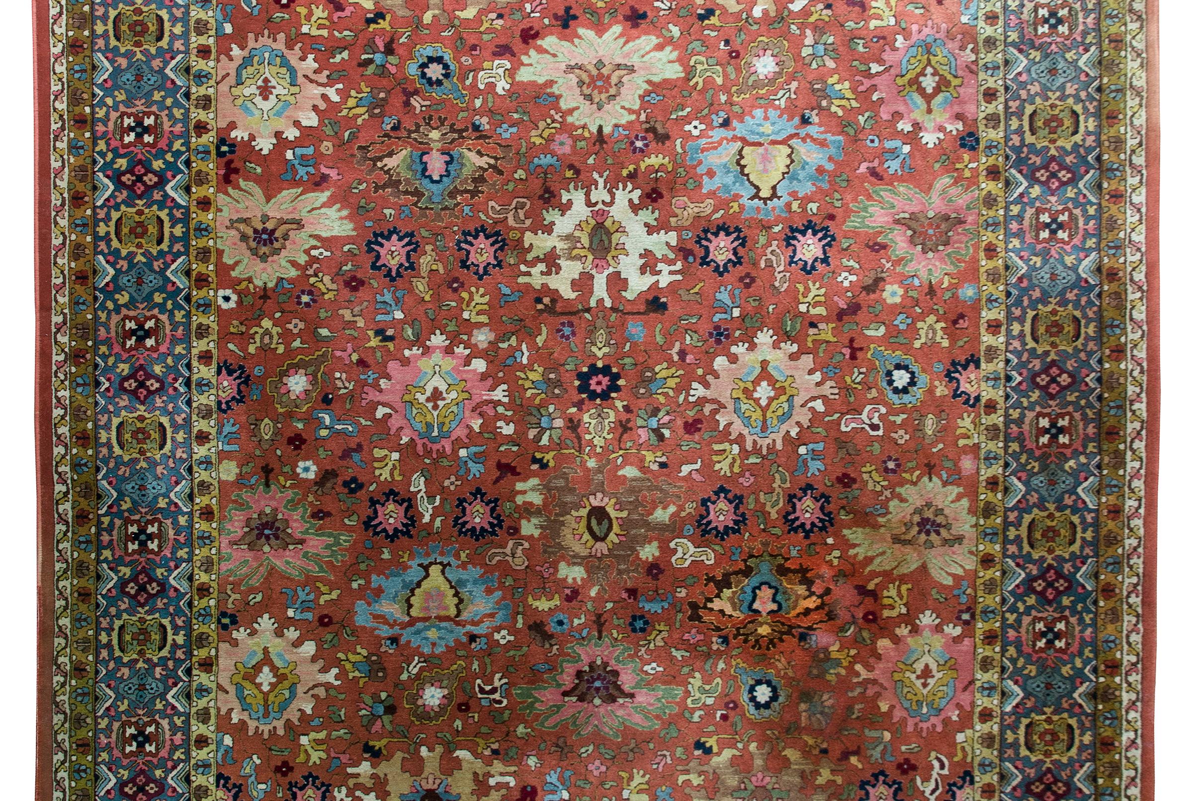 A wonderful early 20th century German Tetex rug woven with a densely woven large-scale floral patterned field surrounded by a wide repeated floral patterned border, and all woven in bold colors including varying shades of indigo, pink, green, coral,