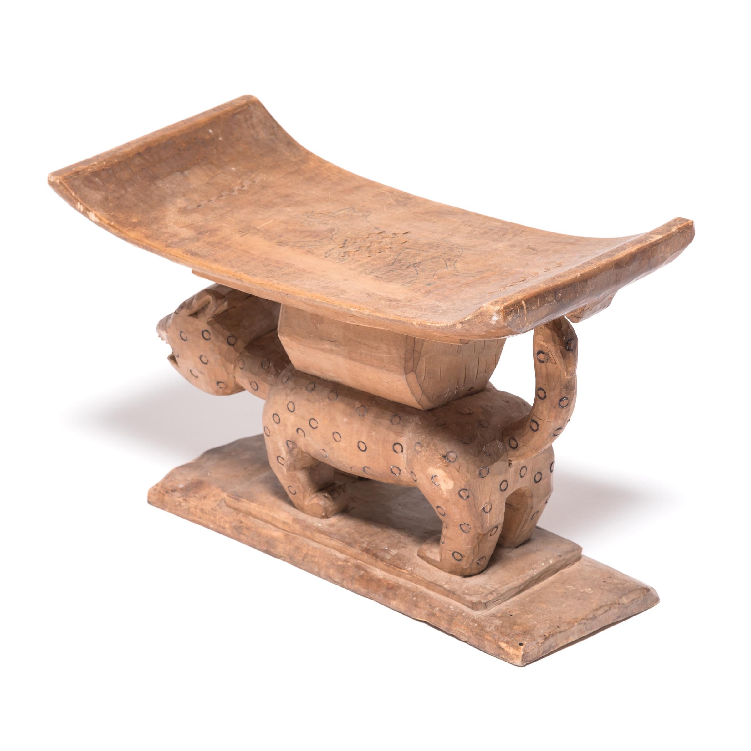 Stools indicated power, status, and lines of succession in traditional Ashanti culture. The platform base, curved seat, and ridged supports reference this as an Ashanti King stool. In Ashanti culture, leopards were symbols of fierce power. King