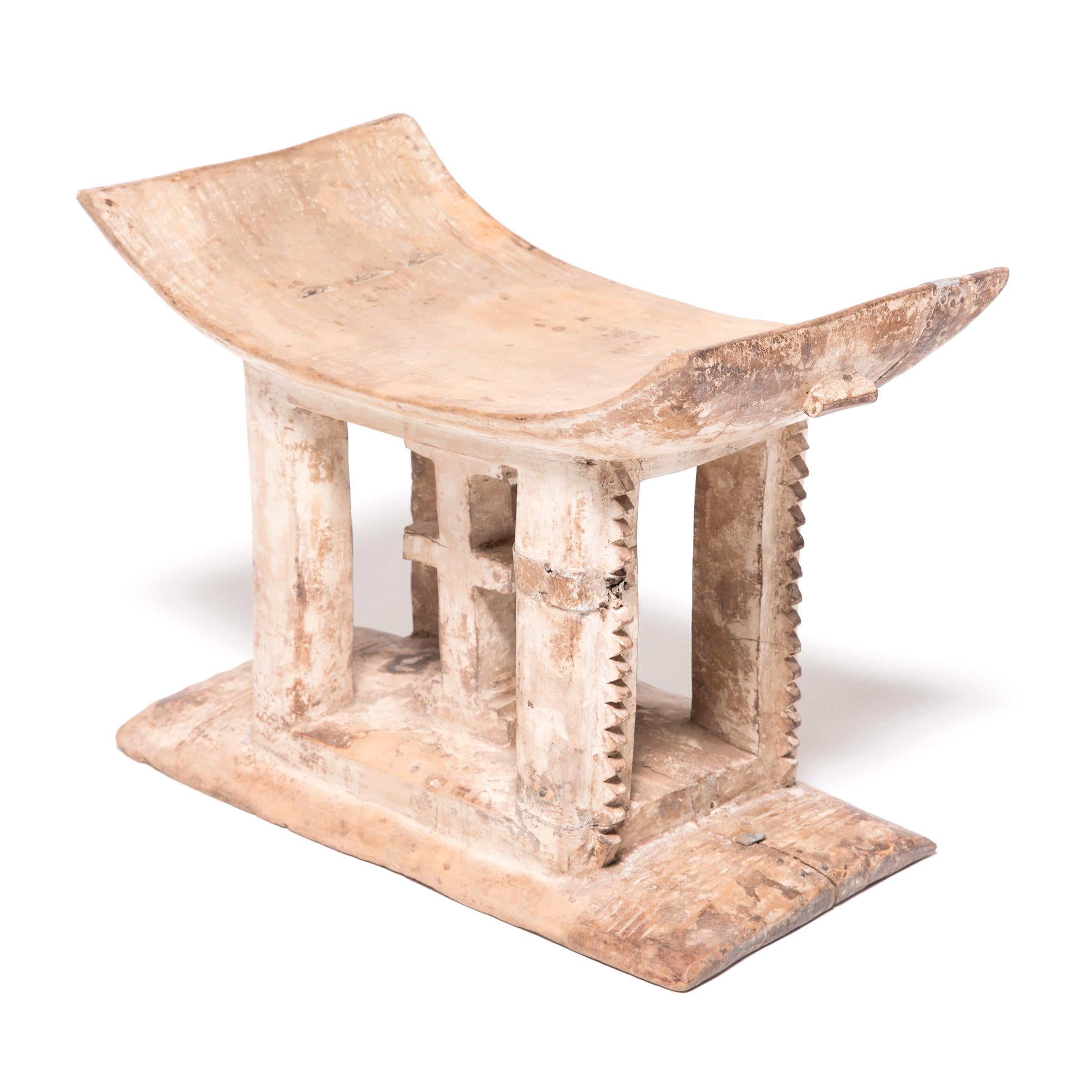Stools indicated power, status, and lines of succession in traditional Ashanti culture. The flat base, curved seat, and ridged supports reference the Ashanti King Stool. This stool presents two central different symbols. The heart 