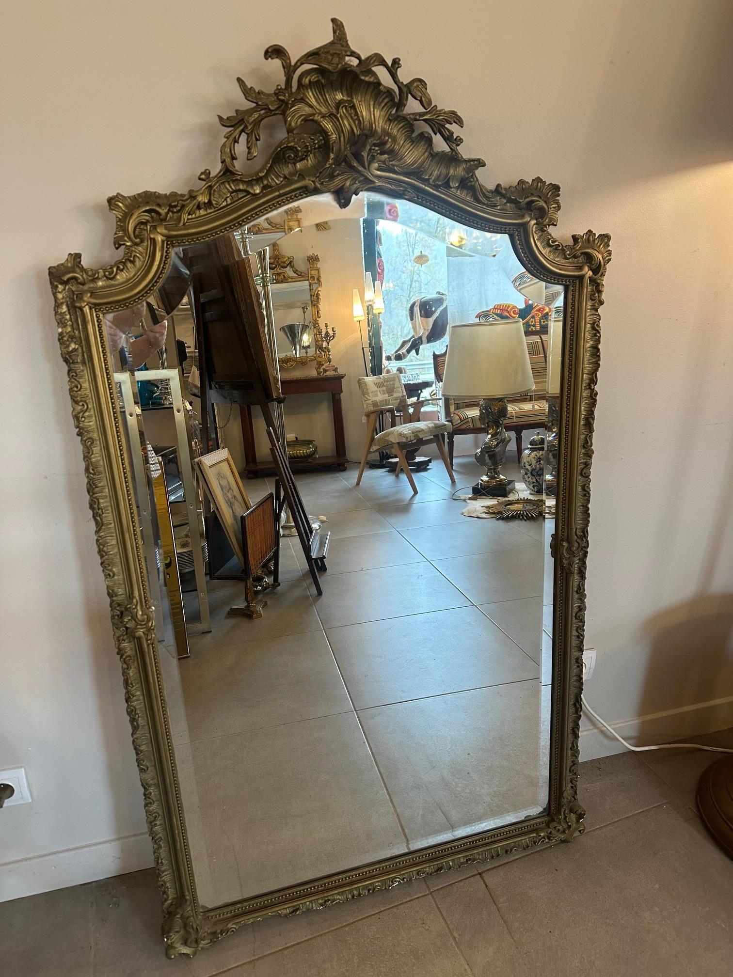 Bellissima specchiera d'epoca risalente ai primi anni del 1900, caratterizzata da una magnifica cornice in legno intagliato e dorato a foglia d'oro, tipica dell'eleganza francese di fine Ottocento e inizio Novecento.
La sua imponente silhouette e i