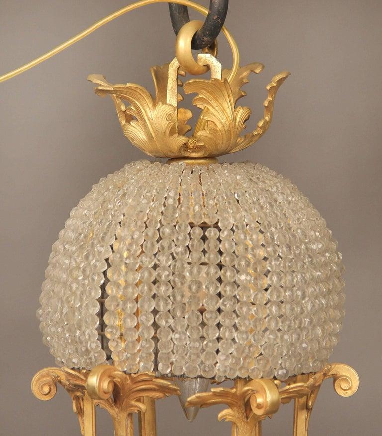 Francese Lampadario a 13 luci con cesto di perline in bronzo dorato dei primi del Novecento in vendita