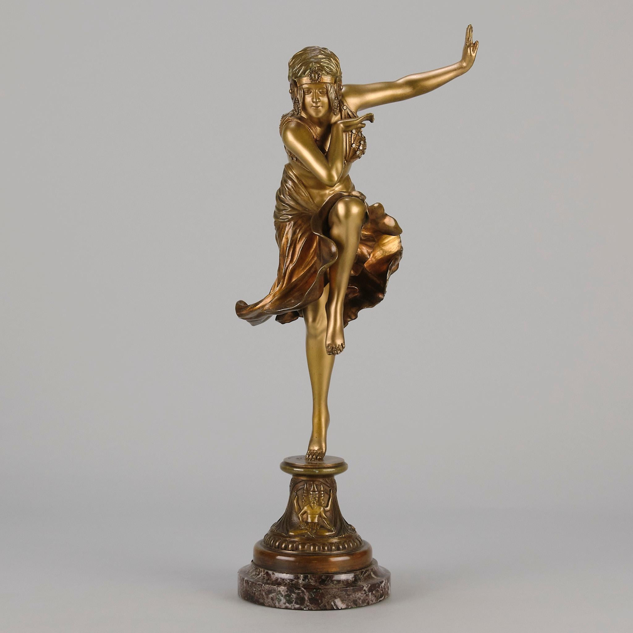 A dramatic early 20th Century French Art Deco gilt and enamel bronze figure of a beautiful elegant dancer in stylised pose wearing an attractive costume and headdress with superb intricate surface detail and colour, raised on an intergral shaped