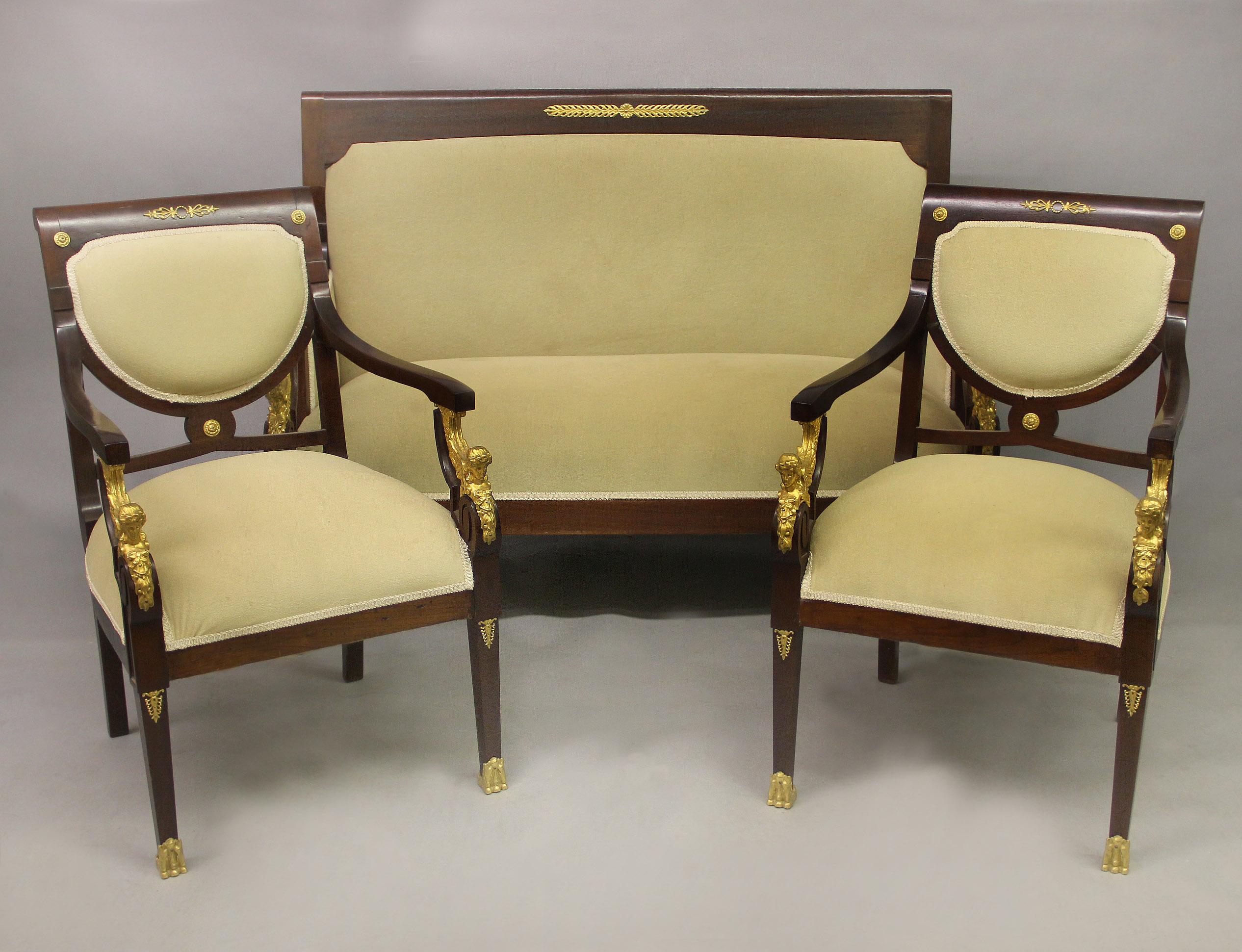 A nice late 19th / early 20th century gilt bronze mounted empire style three piece parlor set.

Comprising of a settee and a pair of armchairs.

The rectangular backs leading to wavy arms, each supported by gilt bronze female sphinx with spread
