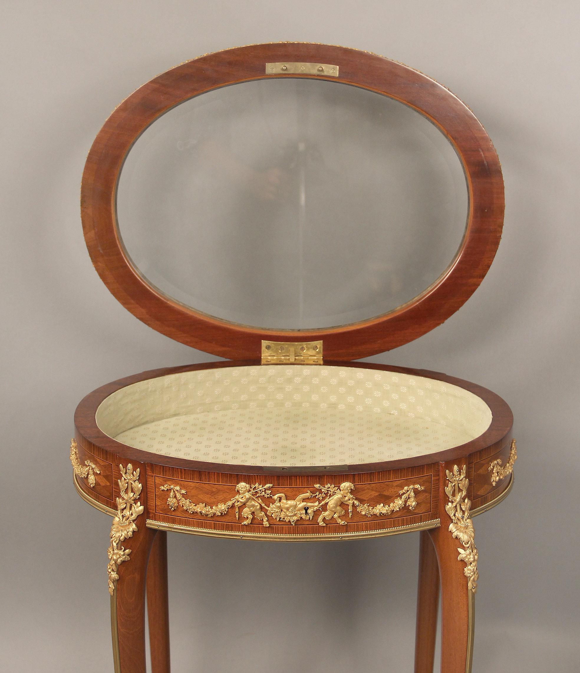 A lovely early 20th century Louis XV style gilt bronze mounted parquetry vitrine table by François Linke

François Linke

The oval shaped table with a beveled glass top encircled by an all floral frieze, the front and back with matching bronze