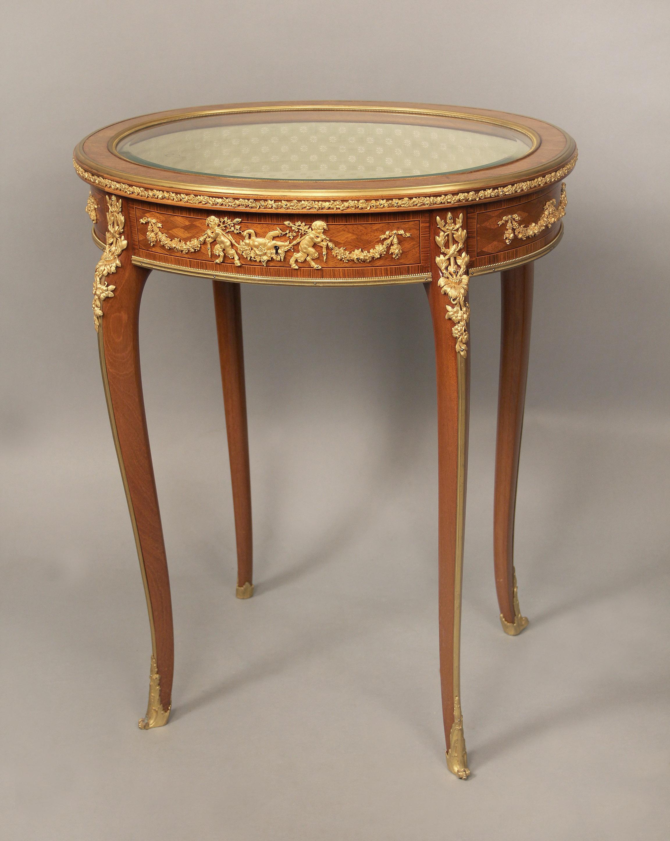 Magnifique table vitrine en parqueterie de style Louis XV du début du 20e siècle, montée sur bronze doré, par François Linke

François Linke

La table de forme ovale avec un plateau en verre biseauté entouré d'une frise florale, l'avant et l'arrière