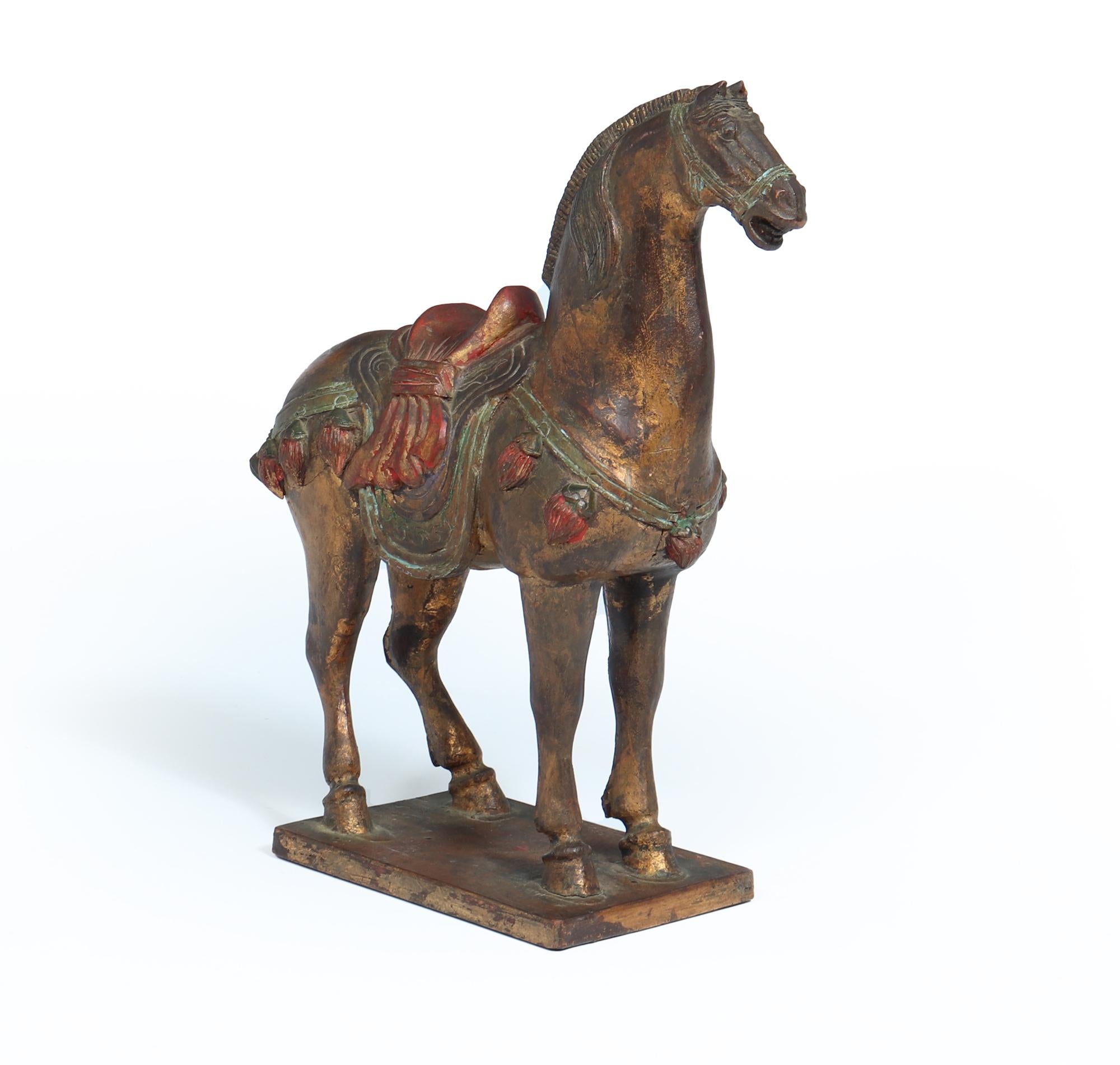 VERGOLDETES HÖLZERNES TANG-KRIEGSPFERD
Eine elegante chinesische vergoldete polychrome Holzschnitzerei im Stil der Tang-Dynastie Pferdeskulptur. Dieses atemberaubende Stück zeichnet sich durch aufwändige Schnitzereien und lebendige, handgemalte