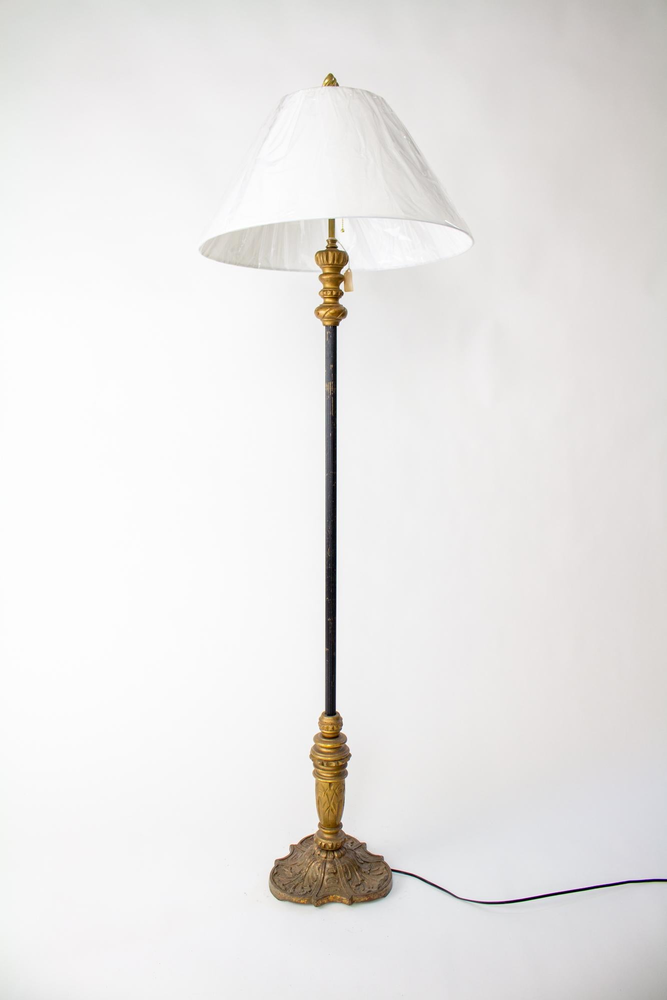 Early 20th Century giltwood and metal floor lamp with two light cluster. Spanish Revival style, would accent a space with victorian, revival, or bohemian styling. Giltwood with original finish, in a dark antique gold with some wear due to its age.