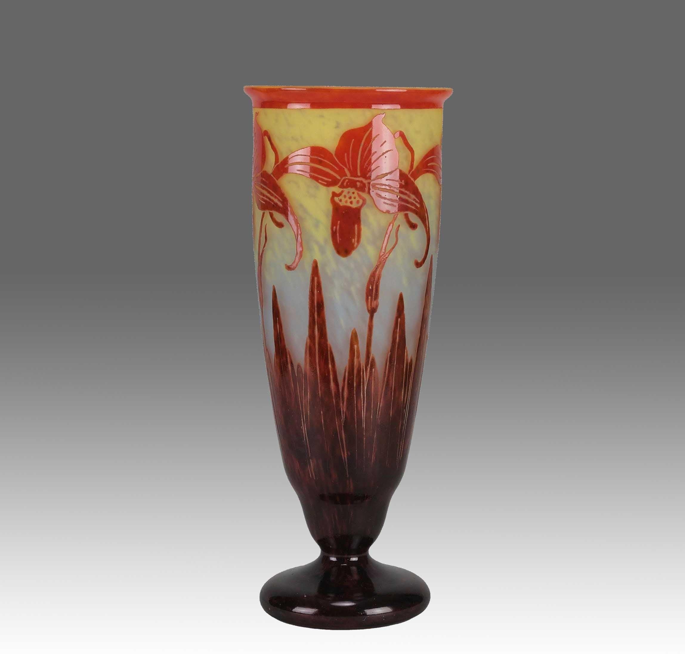 Un meraviglioso vaso in vetro Art Deco dei primi del Novecento, inciso con orchidee rosse vibranti su uno sfondo arancione intenso intervallato da scogliere bordeaux intenso, che mostra colori e dettagli eccellenti. Il bordo della base è firmato Le