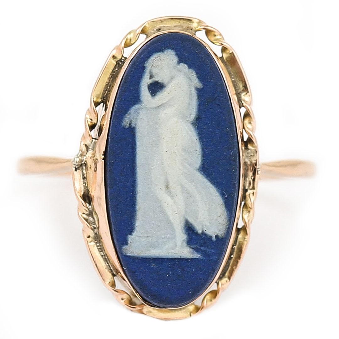 A charming 9ct gold oval shape ring with a Jasperware Wedgwood deep blue panel, depicting the Greek goddess Athena the goddess of wisdom and learning. This deity is shown standing in deep thought, hand to her brow against a plinth. The ring was made