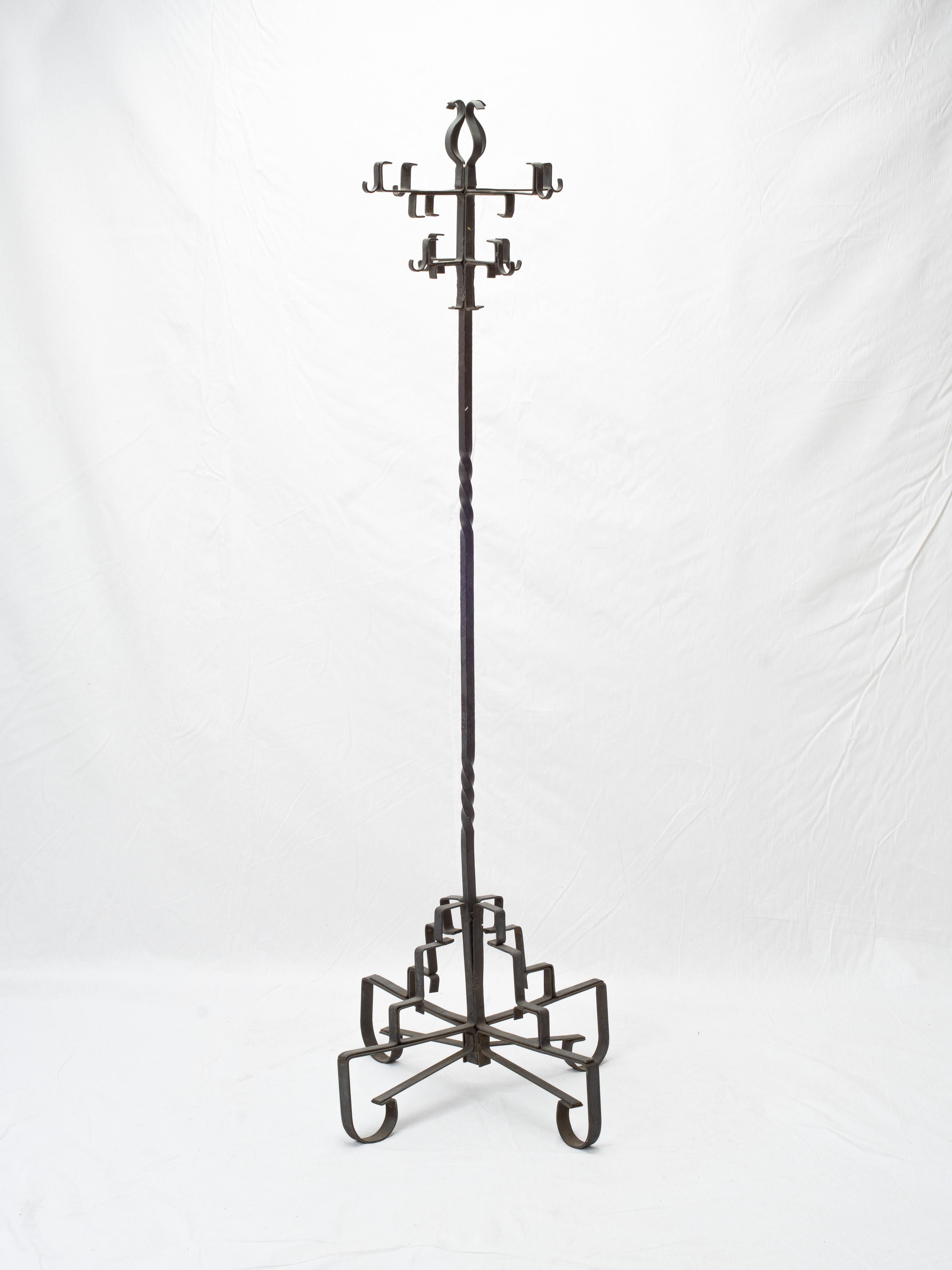 Remarkable example of early 20th century, this coat rack features a beautiful primitive blackened iron finish. The skilled metalwork and angular construction inspires a medieval design appearance. 

The top of the stand displays eight independent