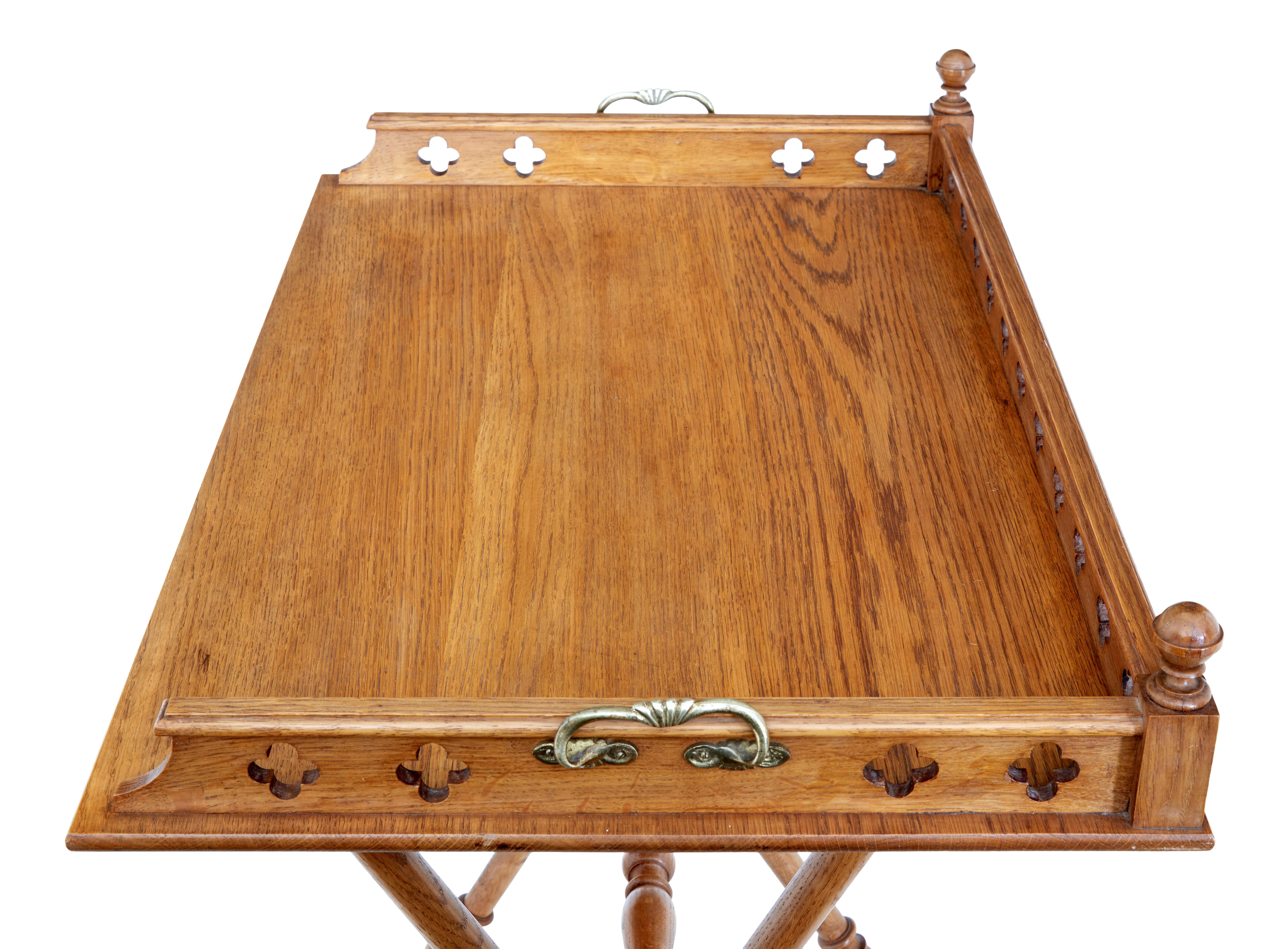 Early 20th century gothic revival oak butlers tray on stand circa 1910.

Good quality butler's tray on original stand.  Tray with tracery elements to the gallery, further decorated with turned finials and brass handles.  Tray stands on a profusely