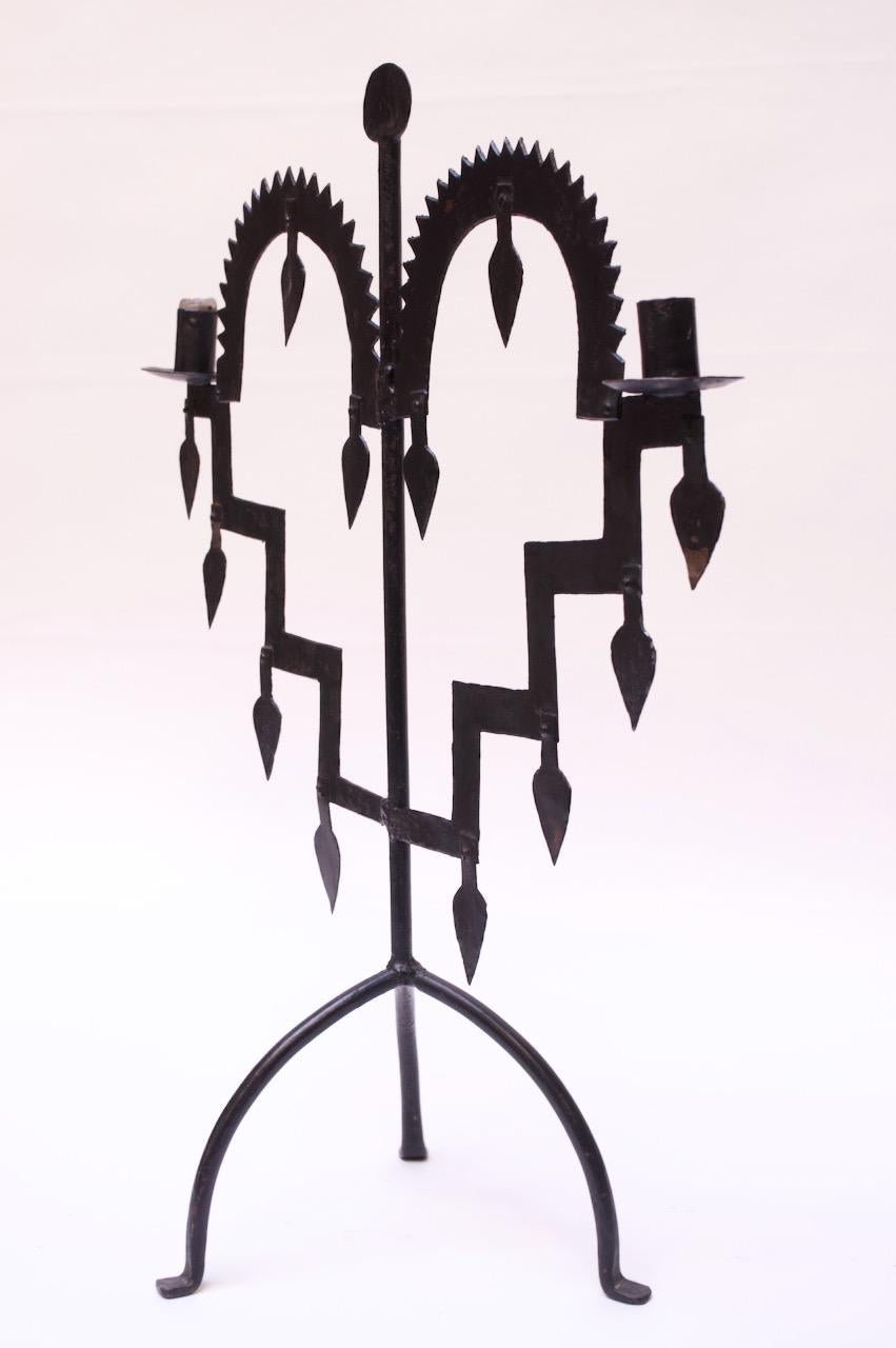 Tabletop candelabrum in wrought iron supported by a tripod base, circa 1910-1920. Hammered and torch cut details throughout. 
Fine, vintage condition with light wear consistent with age. 
 