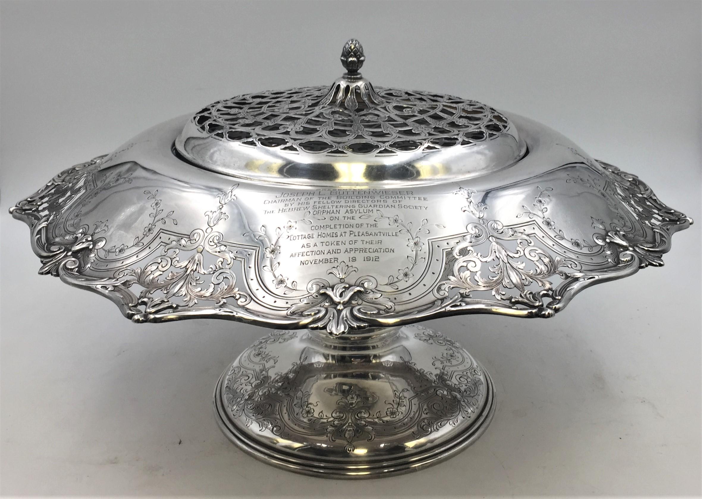 Early 20th century Graff, Washbourne & Dunn sterling silver rose bowl centerpiece with grill for flowers and a body with floral pierced rim and engravings, including a dedicatory inscription dated 1912. Measuring 17'' in diameter by 8'' in height