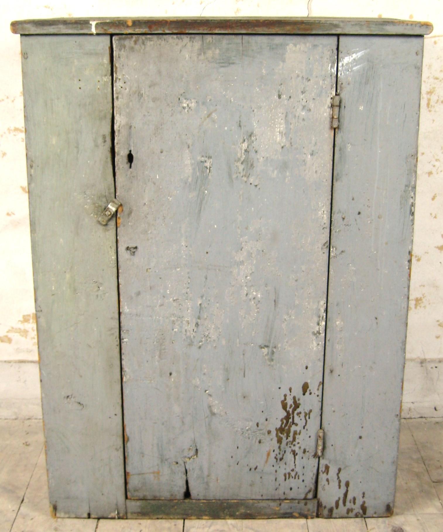 This authentic Primitive Blind door painted 1910s cupboard, it has many layers of paint which are worn through in many spots to reveal the original color. This is a rare find for collectors and enthusiasts of historical furniture. Its timeless style