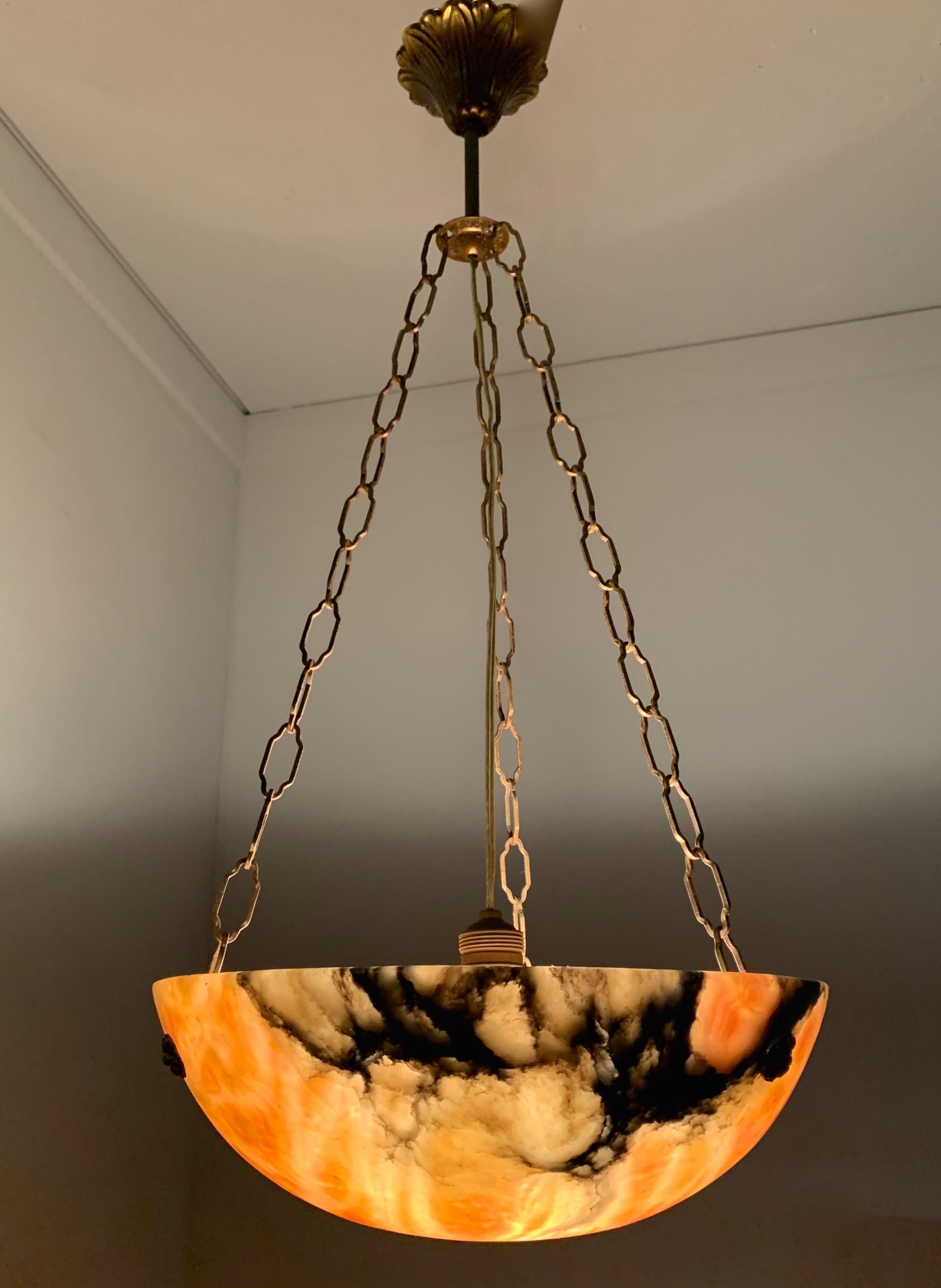 Beautiful 1920s, Art Deco 'burning lava' pendant.

This Art Deco pendant comes with brass chains and canopy and this great combination is a real joy to look at. The perfect circular shape of this pendant, the color and, most of all, the stunning