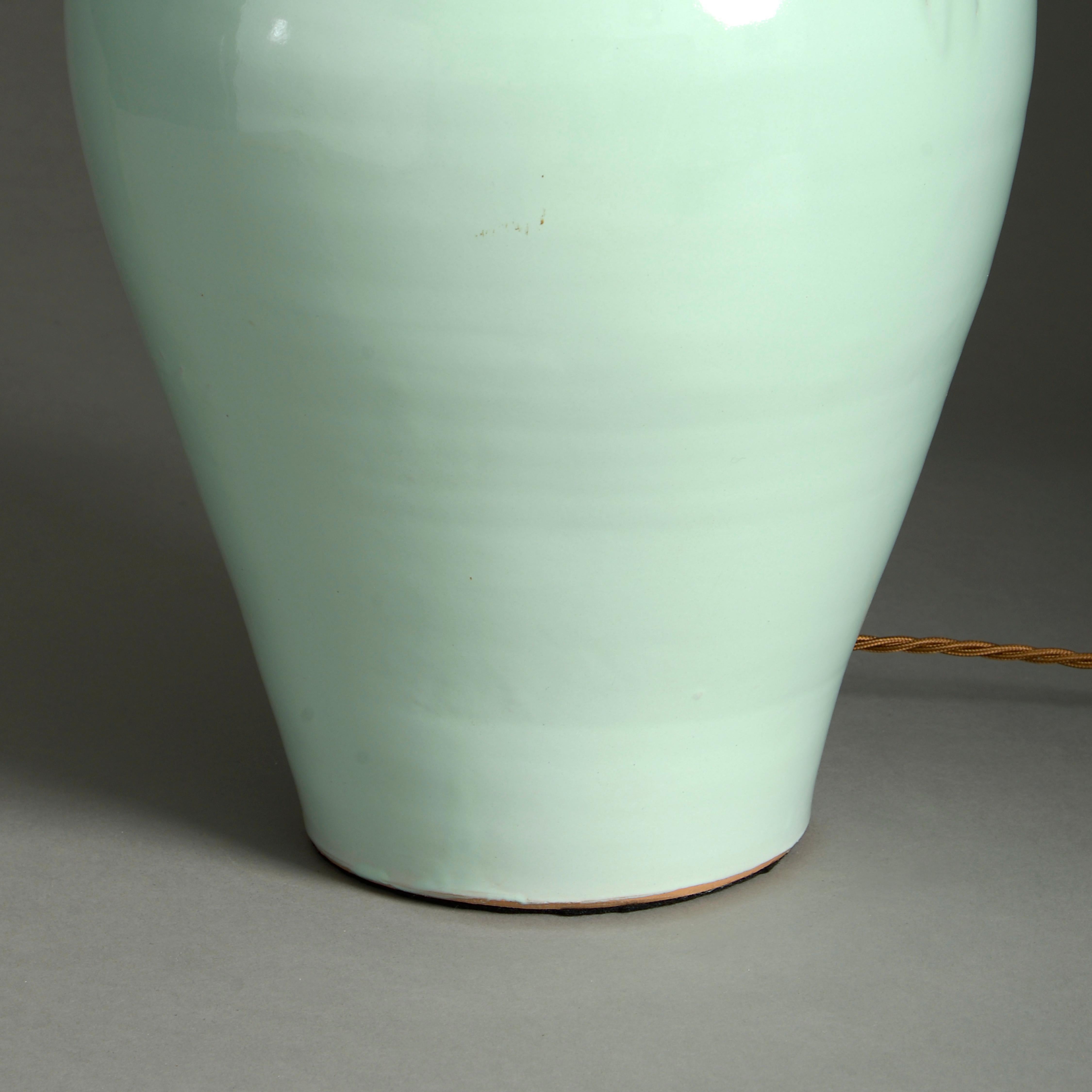 An early 20th century pale green glazed vase of good scale, having carrying handles and now mounted as a table lamp.

Dimensions refer to height of vase only.

Shades available to purchase separately.