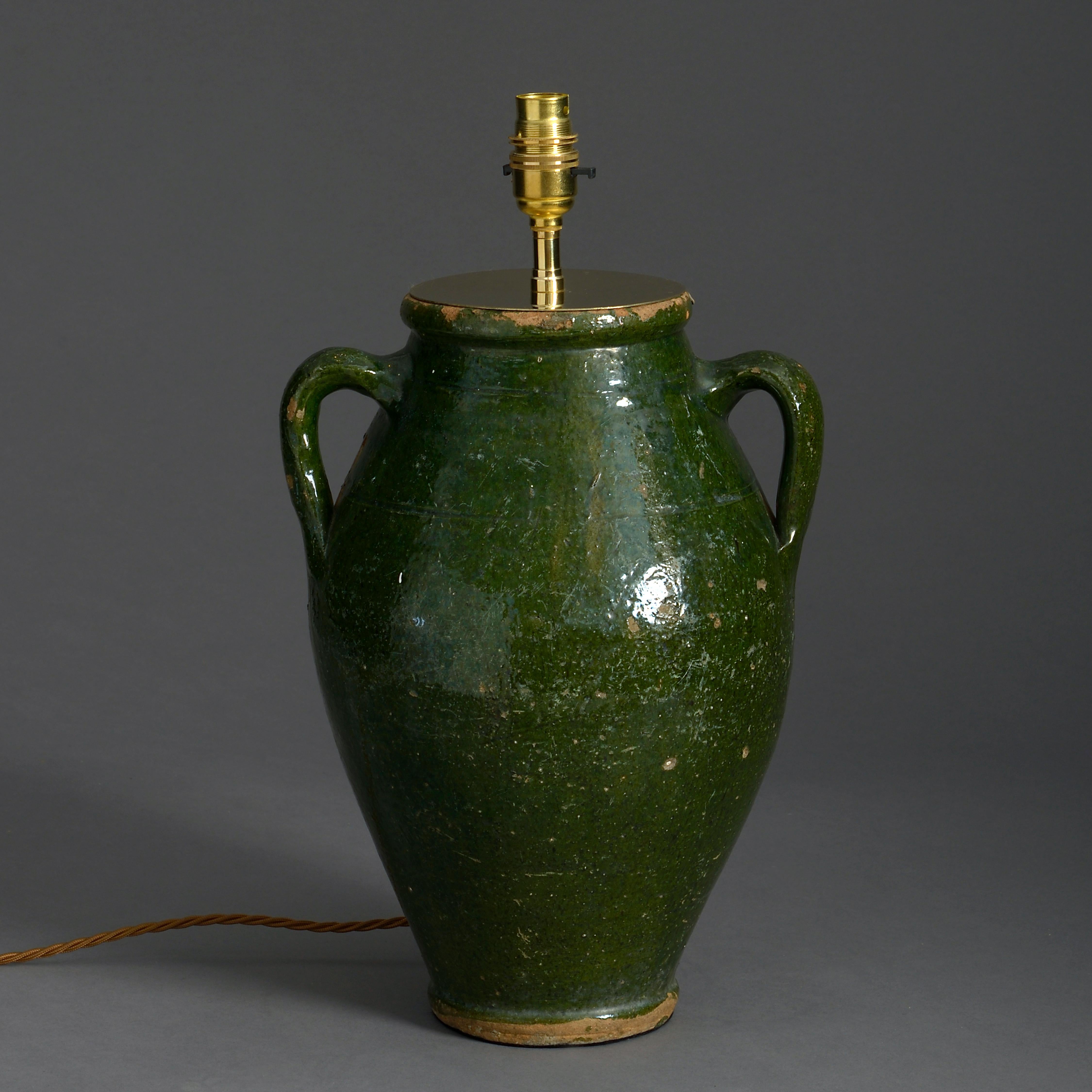 An early 20th century green glazed pottery vase in the classical taste, having two carrying handles.

Now mounted as a lamp.

Height dimension refers to vase only.
 
  