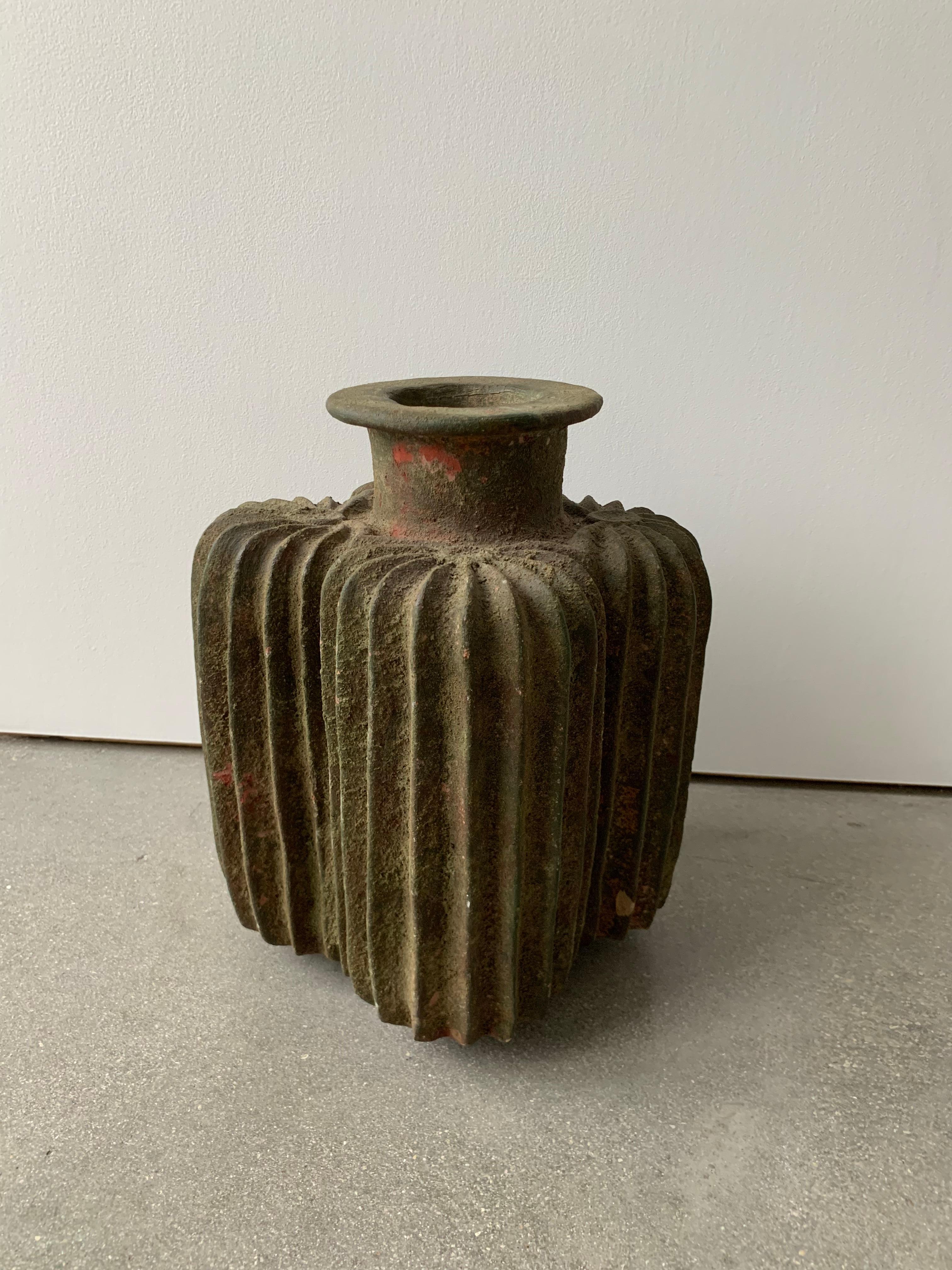 Early 20th century grooved clay vessel was excellently hand crafted with beautifully patina. This piece is large and works great as statement piece both indoors and out. It was created with a unique grooved design with a large lipped opening.