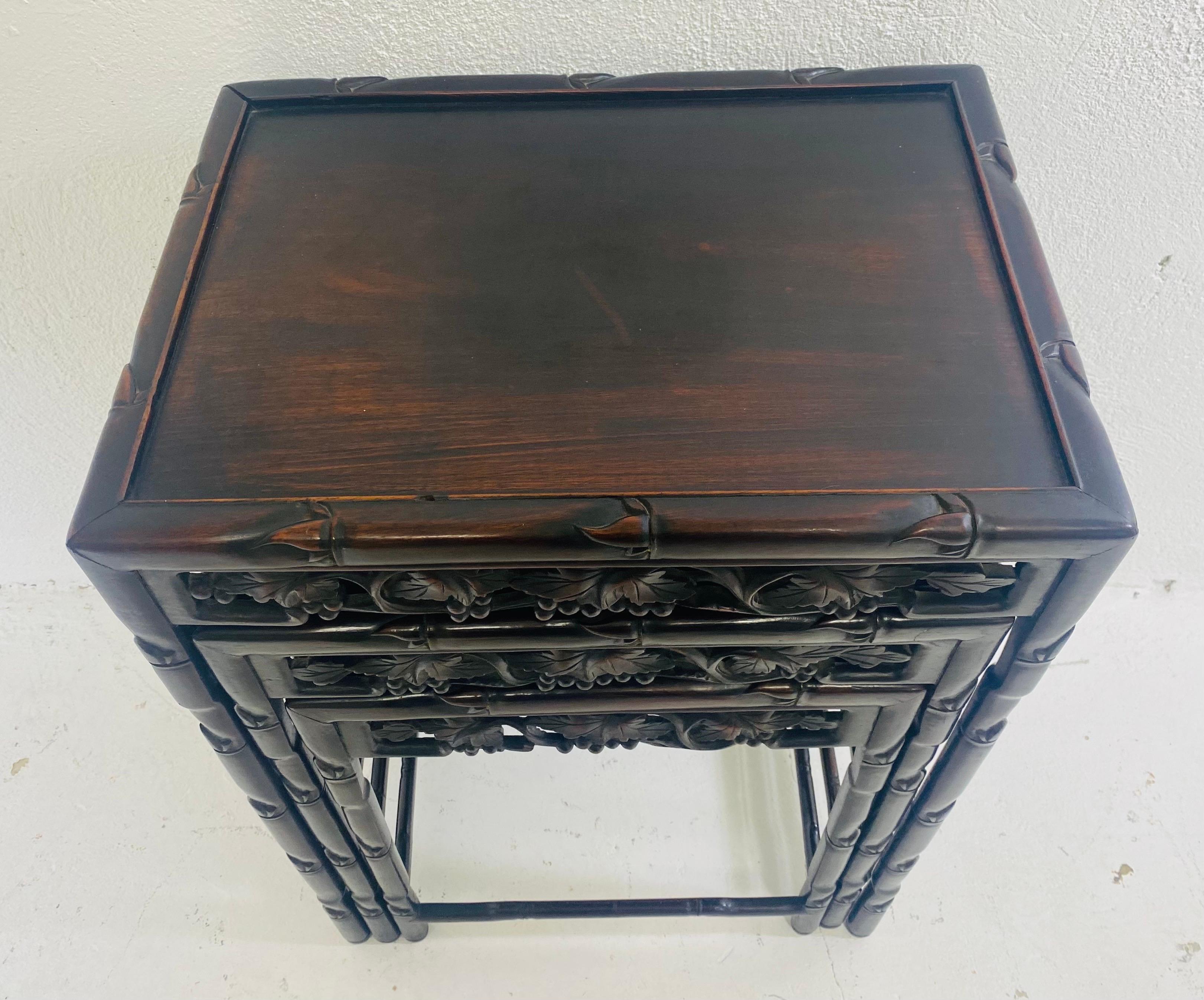 This is a mid 20th century hand carved mahogany nest of tables. These tables have beautiful hand carved floral decoration around the apron of each of the three tables. The tables legs have a delicate leaf decoration and are constructed of dark