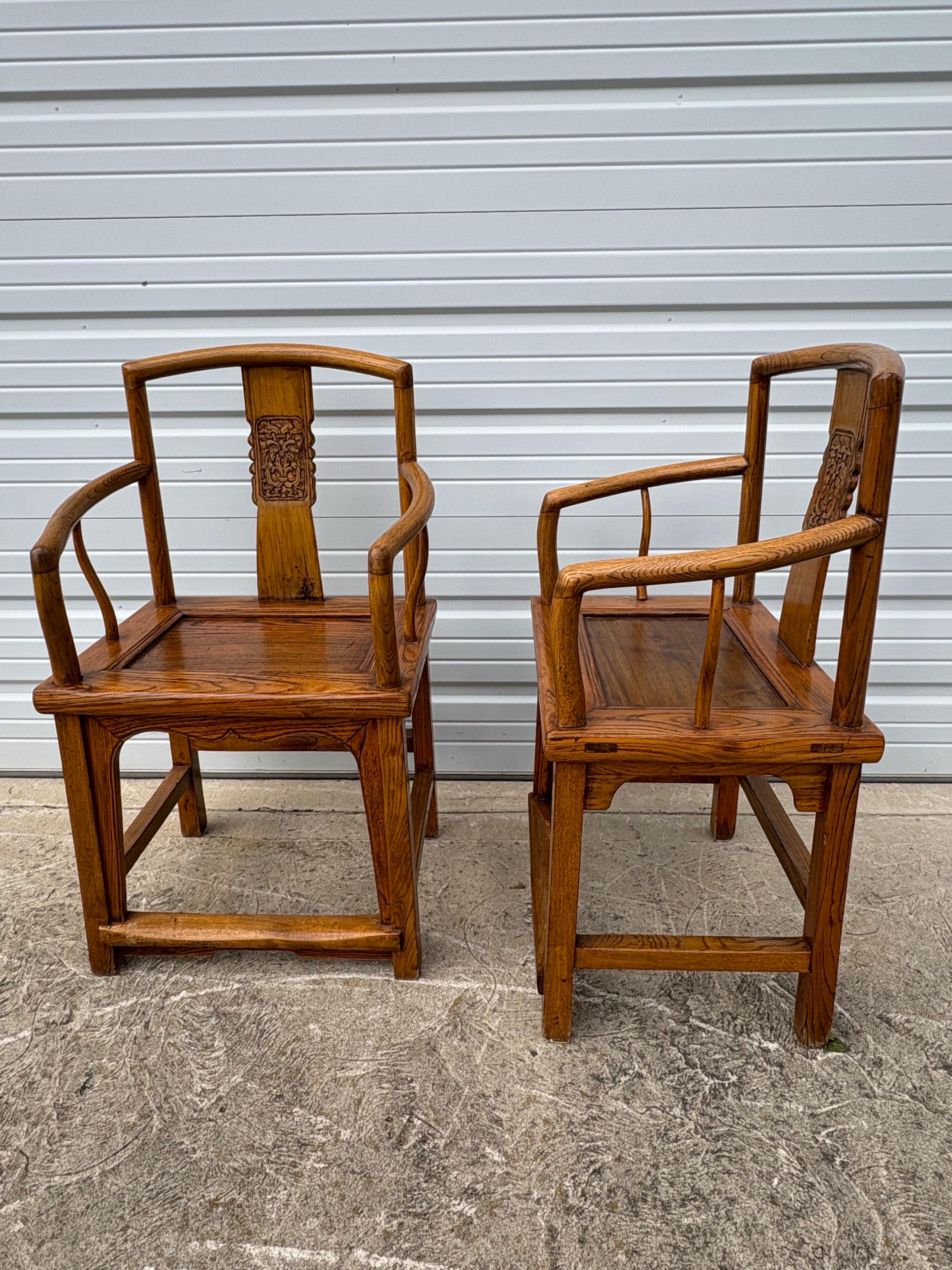 Dies ist ein Paar von Anfang des 20. Jahrhunderts Hand geschnitzt chinesischen Beistelltische. Dieses Stuhlpaar zeichnet sich durch handgeschnitzte, filigrane Details an der Rückenlehne und schön geschwungene Armlehnen aus. Die Stühle sind komplett