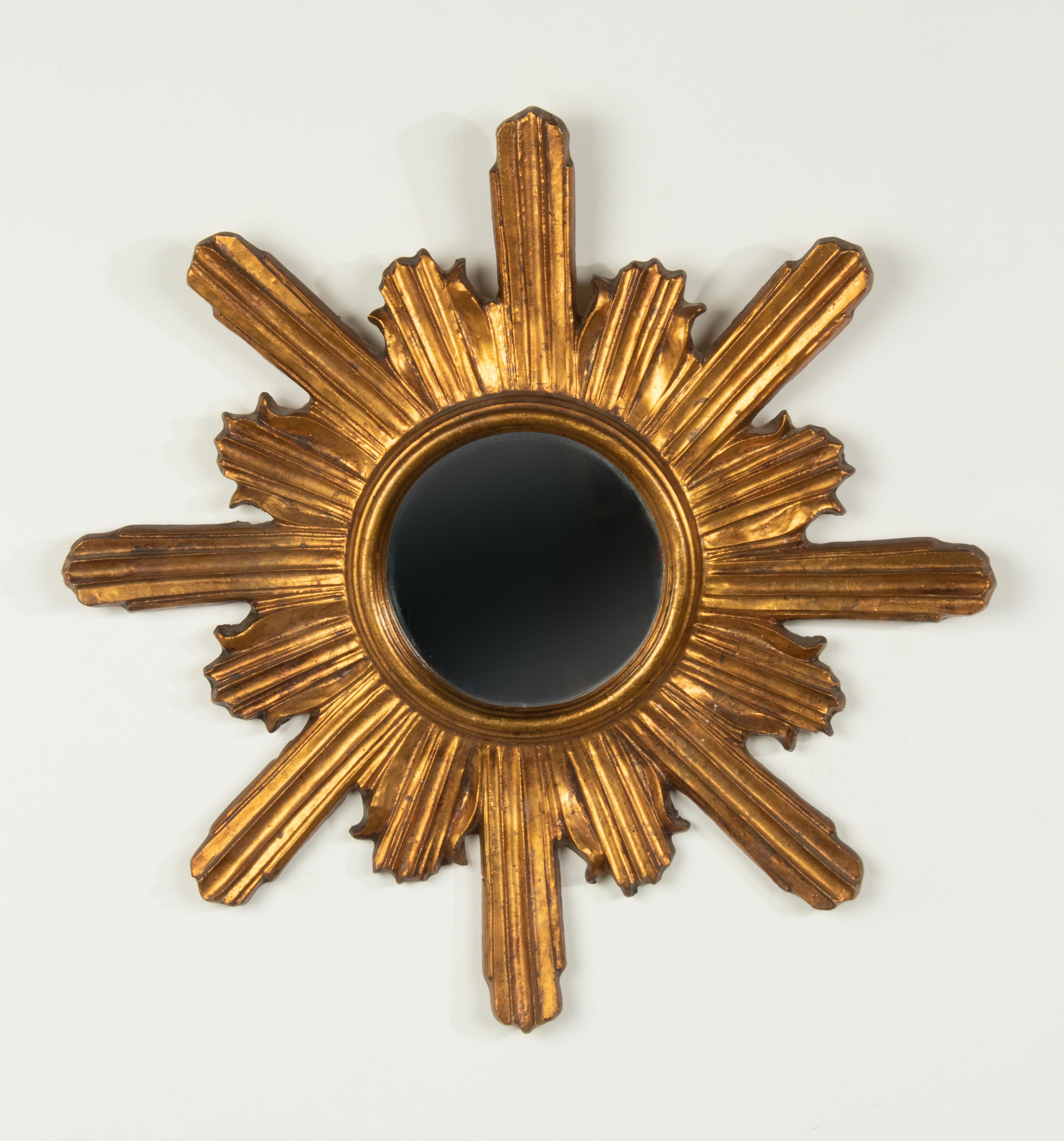 Beautiful antique gilt wood sunburst mirror. The mirror is made of hand carved wood, with gilt patina. With a flat glass mirror. Wood and glass are in good condition. Dating from circa 1920-1930, presumably of French manufacture. 
Dimension: 59 x 59