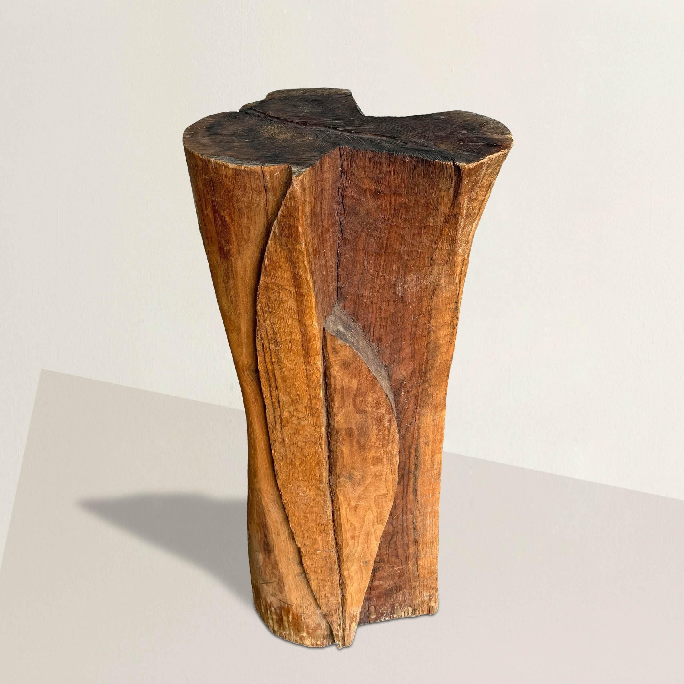 This early 20th-century American Modernist hand-carved wood pedestal is a sculptural masterpiece, evoking the essence of artistic expression and practicality. Adorned with thousands of meticulously carved chips, its surface invites touch and