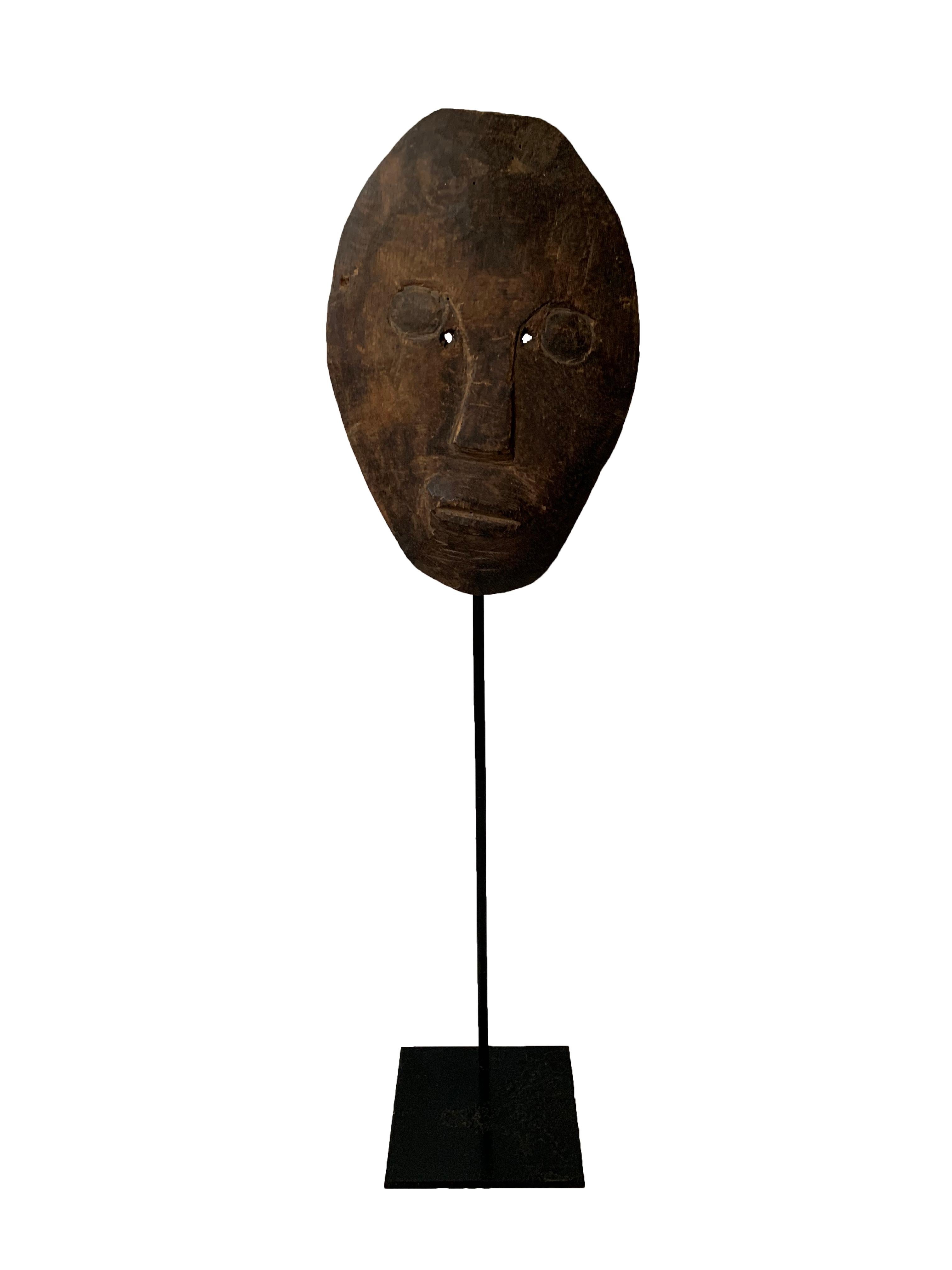 This very flat mask originates from the Atoni people of Timor, featuring two very small eye holes. For the Timorese people masks portray both male and female ancestors, worn by warriors to scare off enemies or during ceremonies. Masks in Timor were