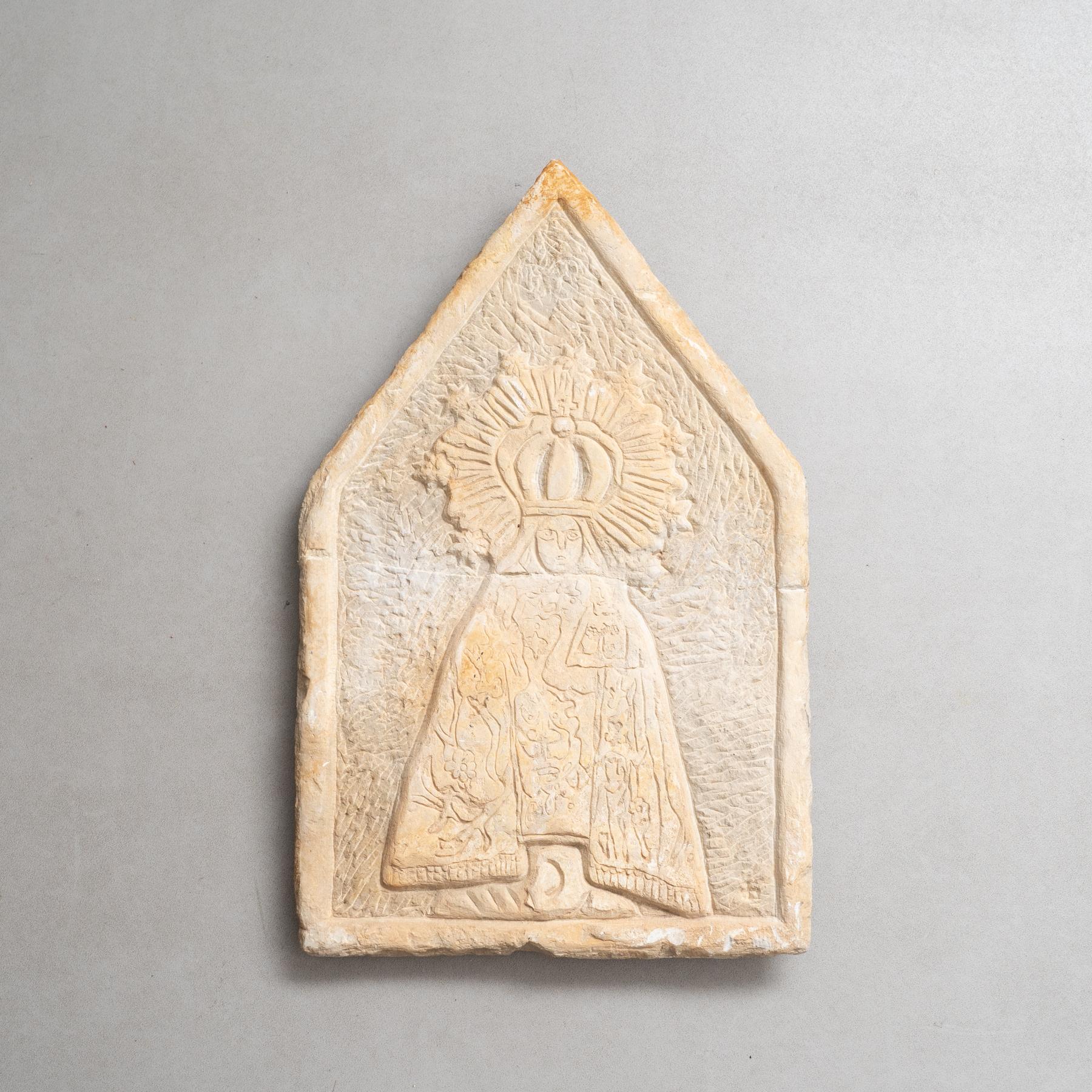 Discover a rare piece of religious art with this early 20th century, circa 1940, hand-engraved wall stone sculpture featuring a serene depiction of a Virgin. This remarkable artifact stands as a testament to the craftsmanship and devotion of its