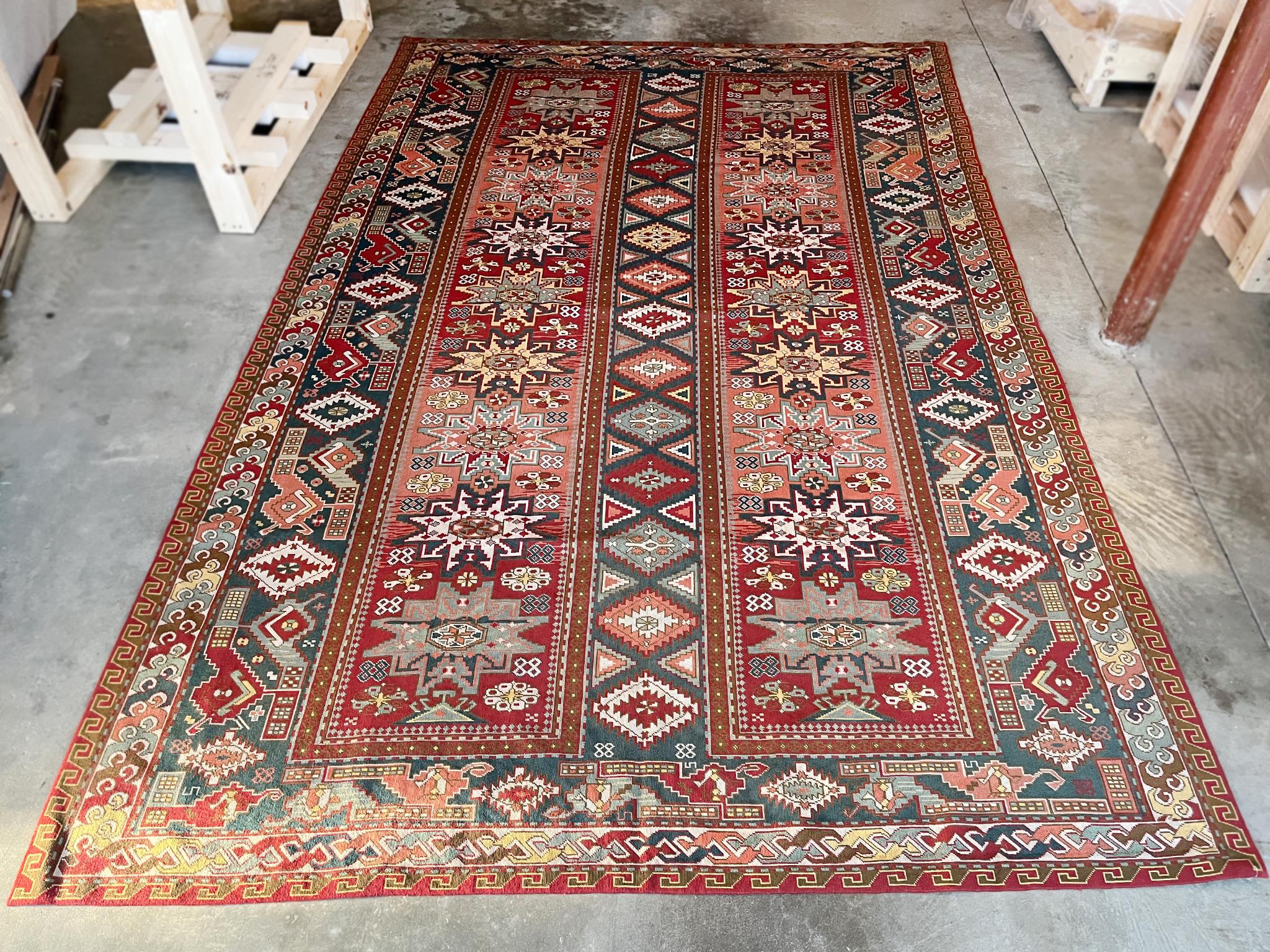 Ce tapis kazakh antique en laine a été noué à la main au début du XIXe siècle dans la région du Caucase.  La palette est un mélange audacieux de rouges, de bleus, de roses et de jaunes. Un dessin complexe de motifs géométriques anime la surface. Ce