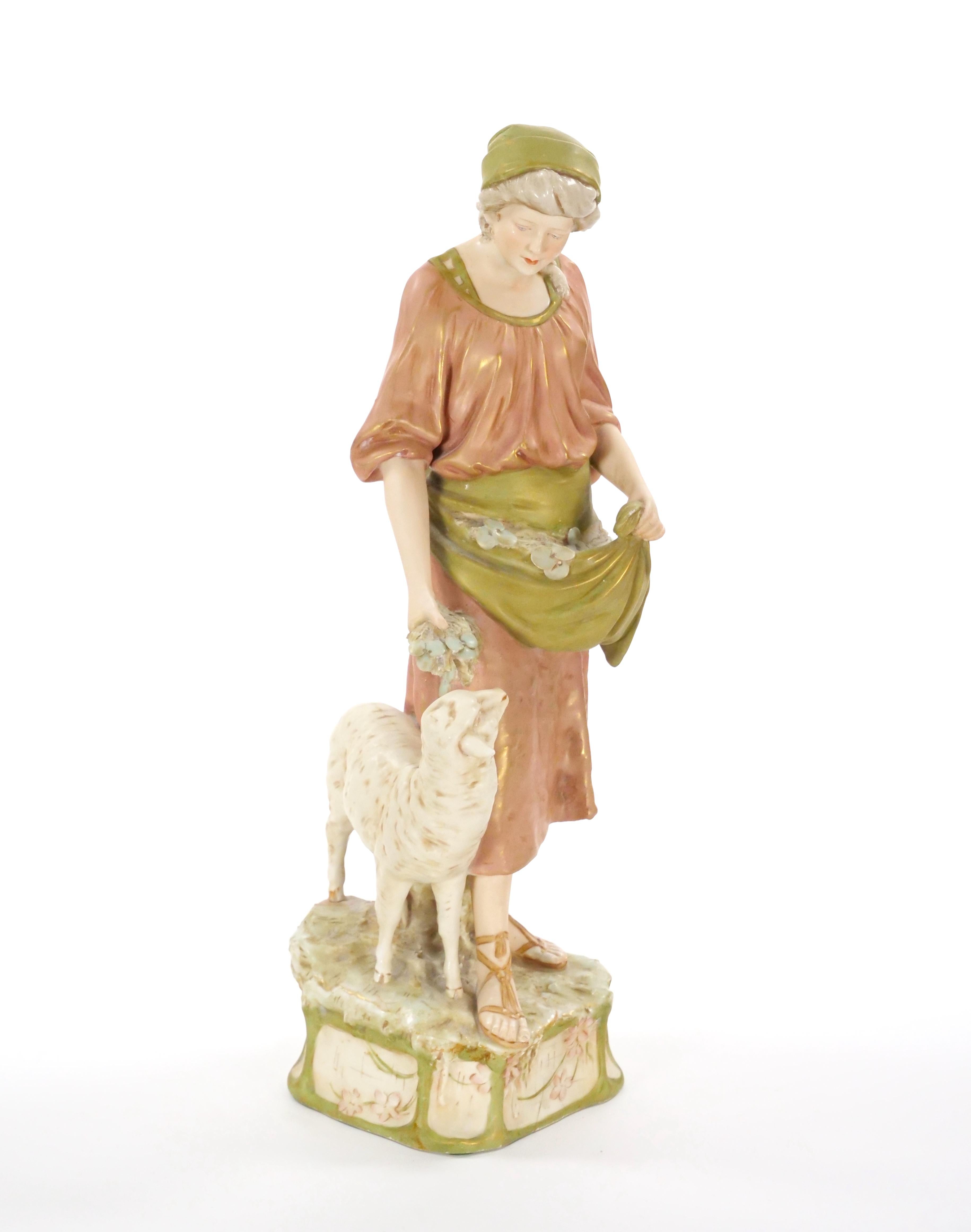 This exquisite early 20th-century porcelain sculpture by Royal Dux showcases the fine craftsmanship and artistic detail characteristic of the renowned Czech manufacturer. The sculpture depicts a woman dressed in elegant period attire, gracefully